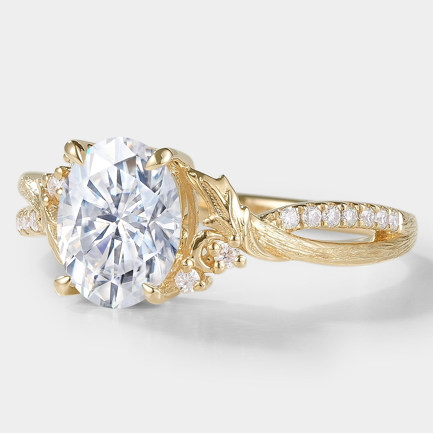 Oval moissanite engagement ring with leaf and bark design in yellow gold. Vintage style bridal ring.