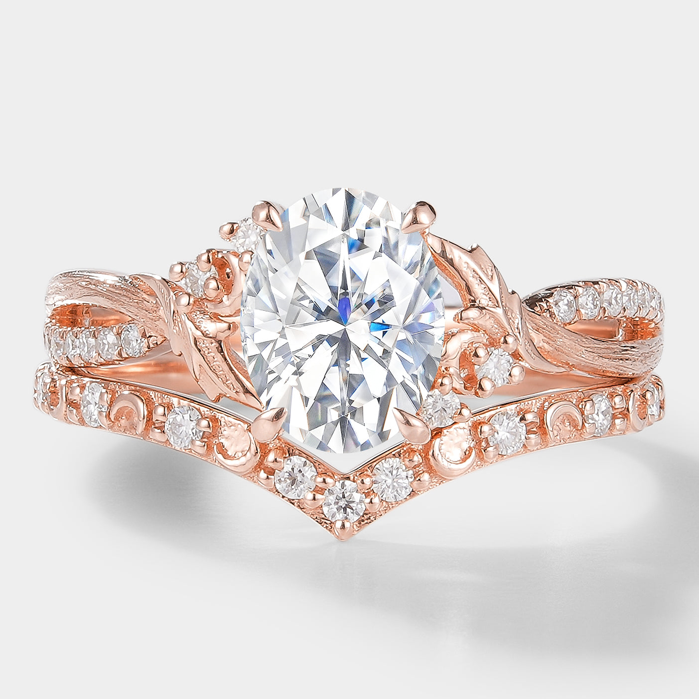 Rose gold moissanite leaf engagement ring set with oval center stone & V-shaped wedding band