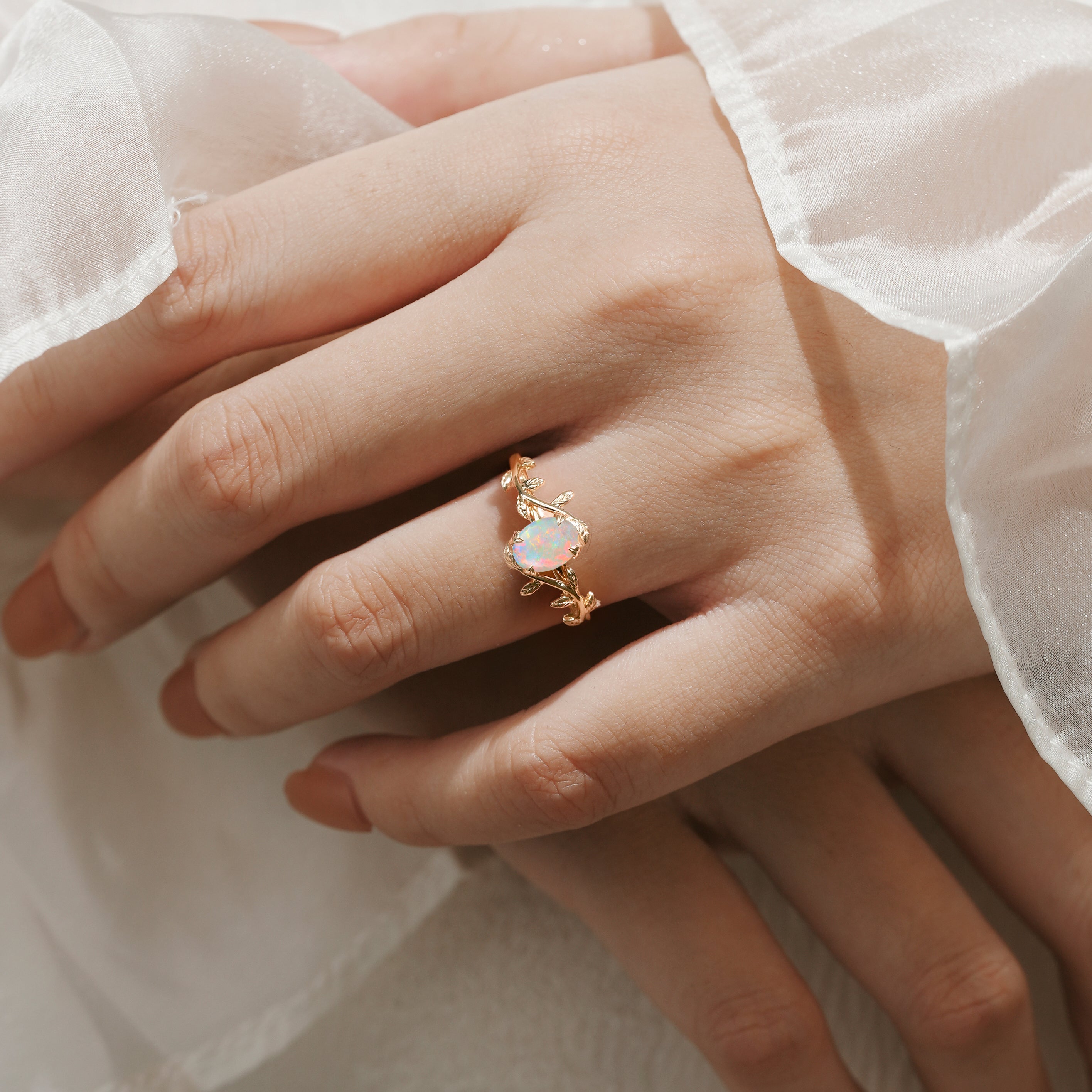 Oval opal engagement ring with leaf accents