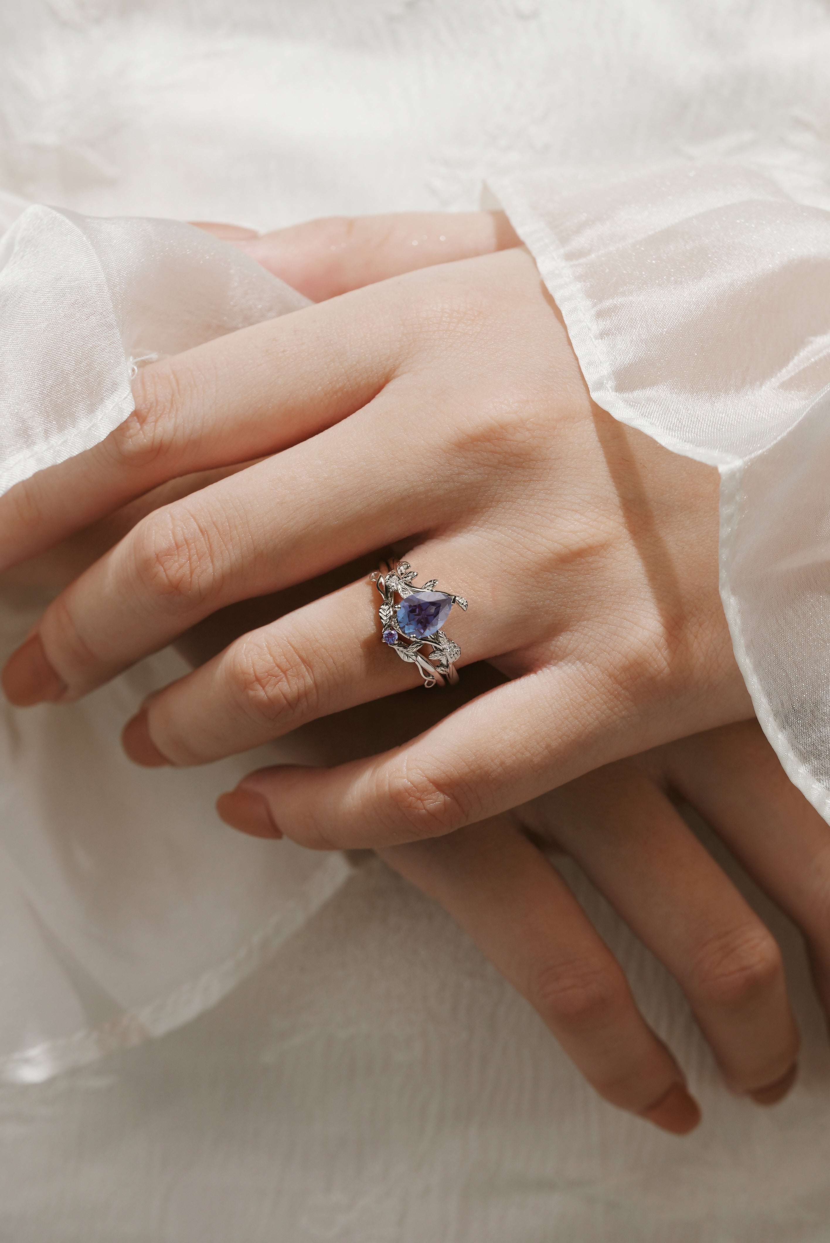 Pear cut alexandrite leaf engagement ring and wedding band set on hand. White gold vintage bridal set.