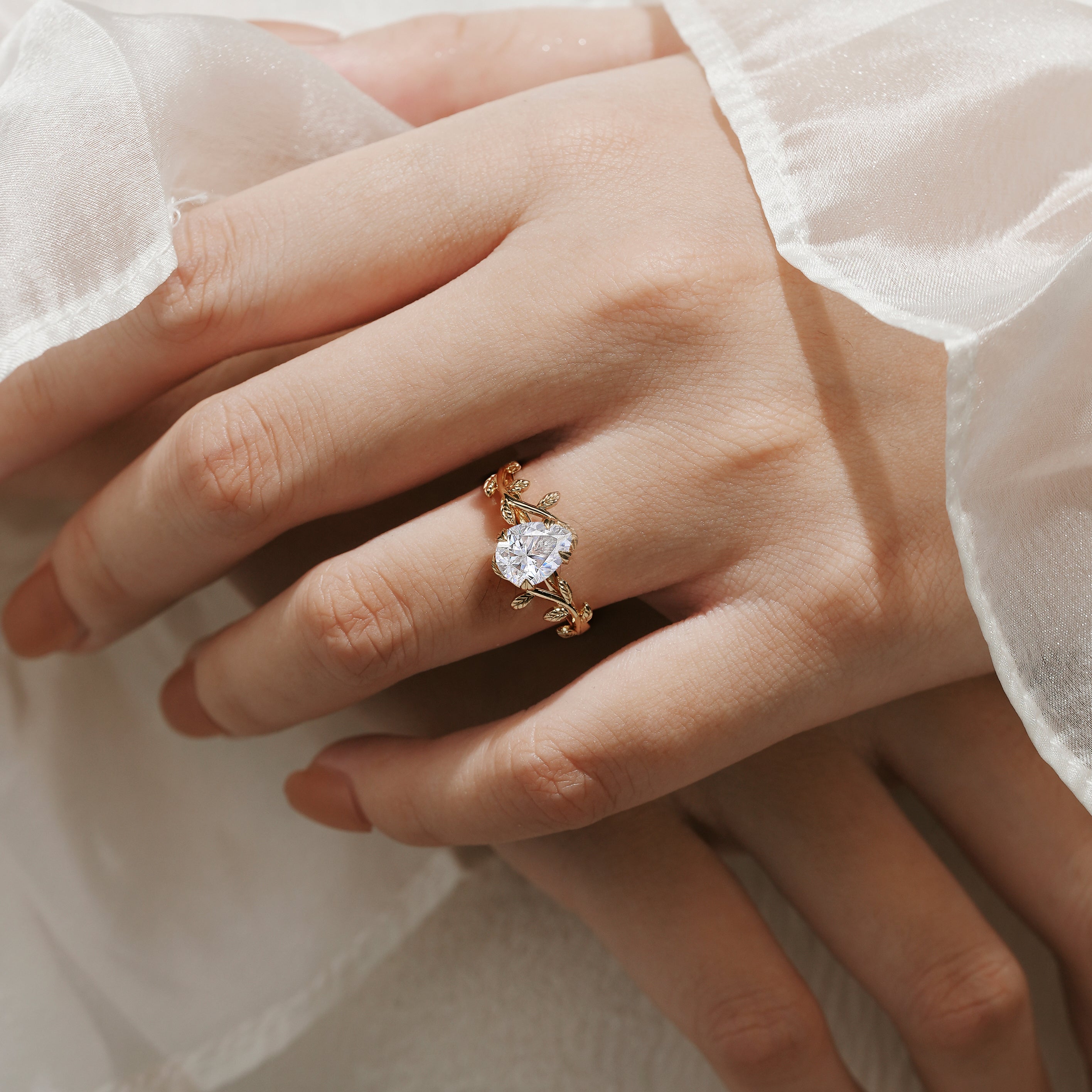 Gold leaf engagement ring with pear-cut moissanite gemstone