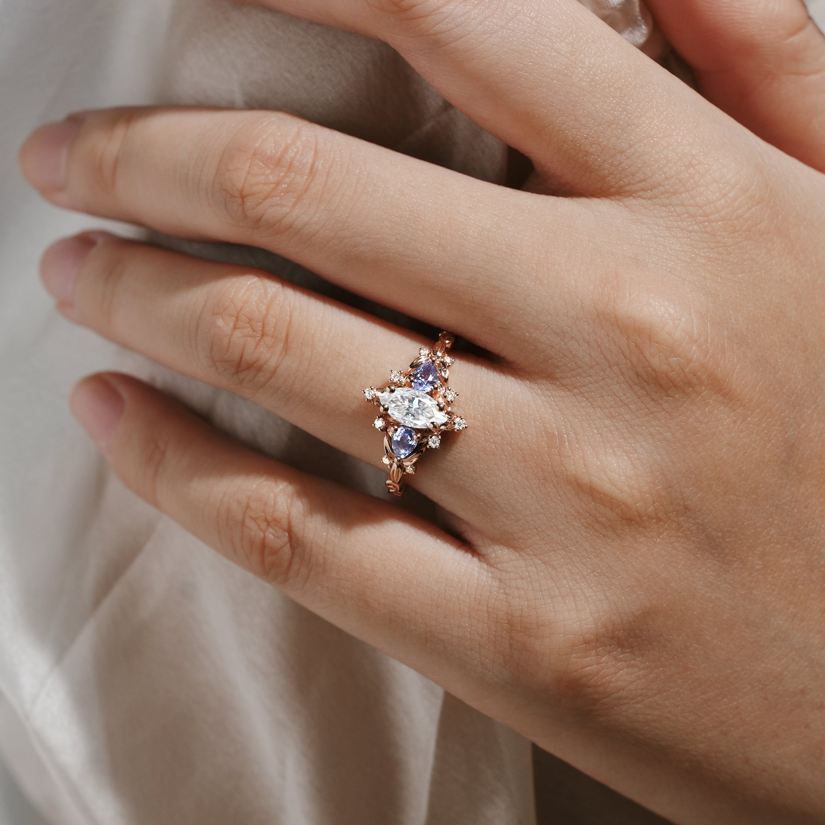 Hand wearing Marquise Cut Moissanite Leaf Engagement Ring with Sapphire Cluster