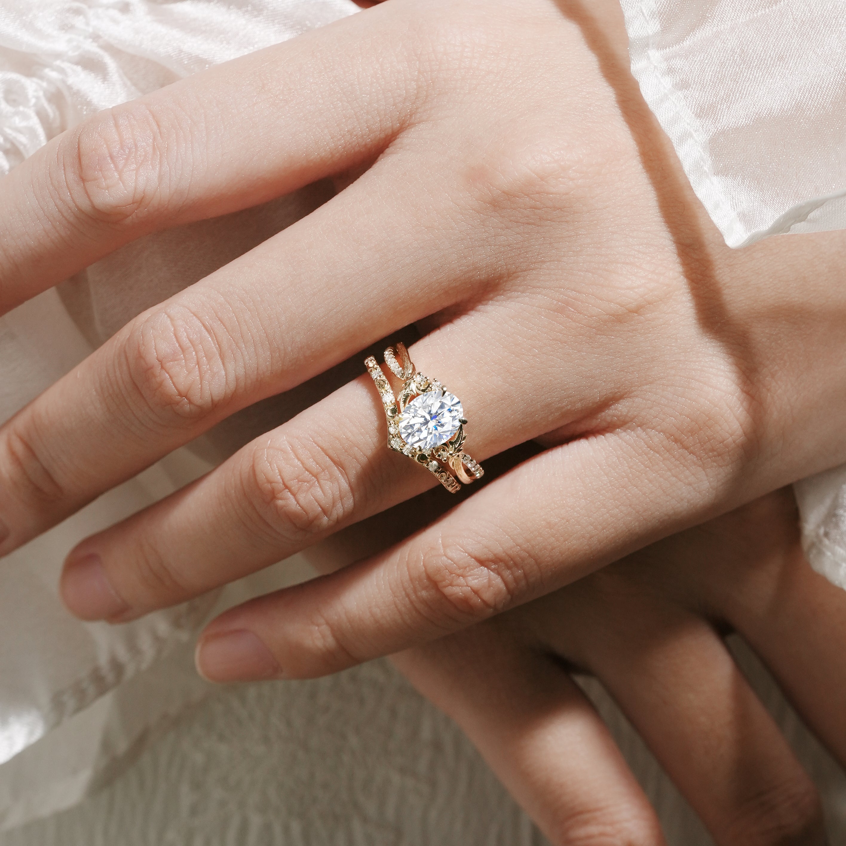 Moissanite leaf engagement ring set on a hand, 14k gold bridal set with bark texture and V-shaped wedding band