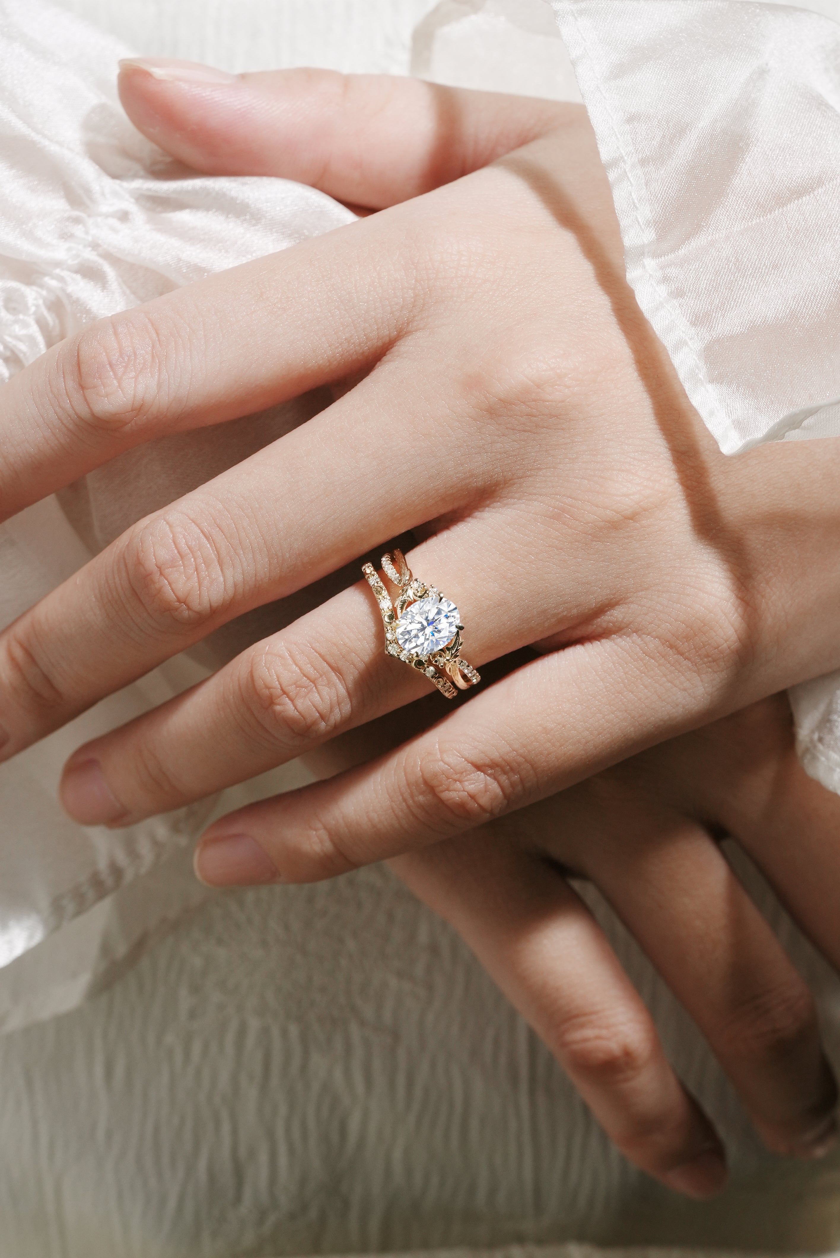 Moissanite leaf engagement ring set on a hand, 14k gold bridal set with bark texture and V-shaped wedding band