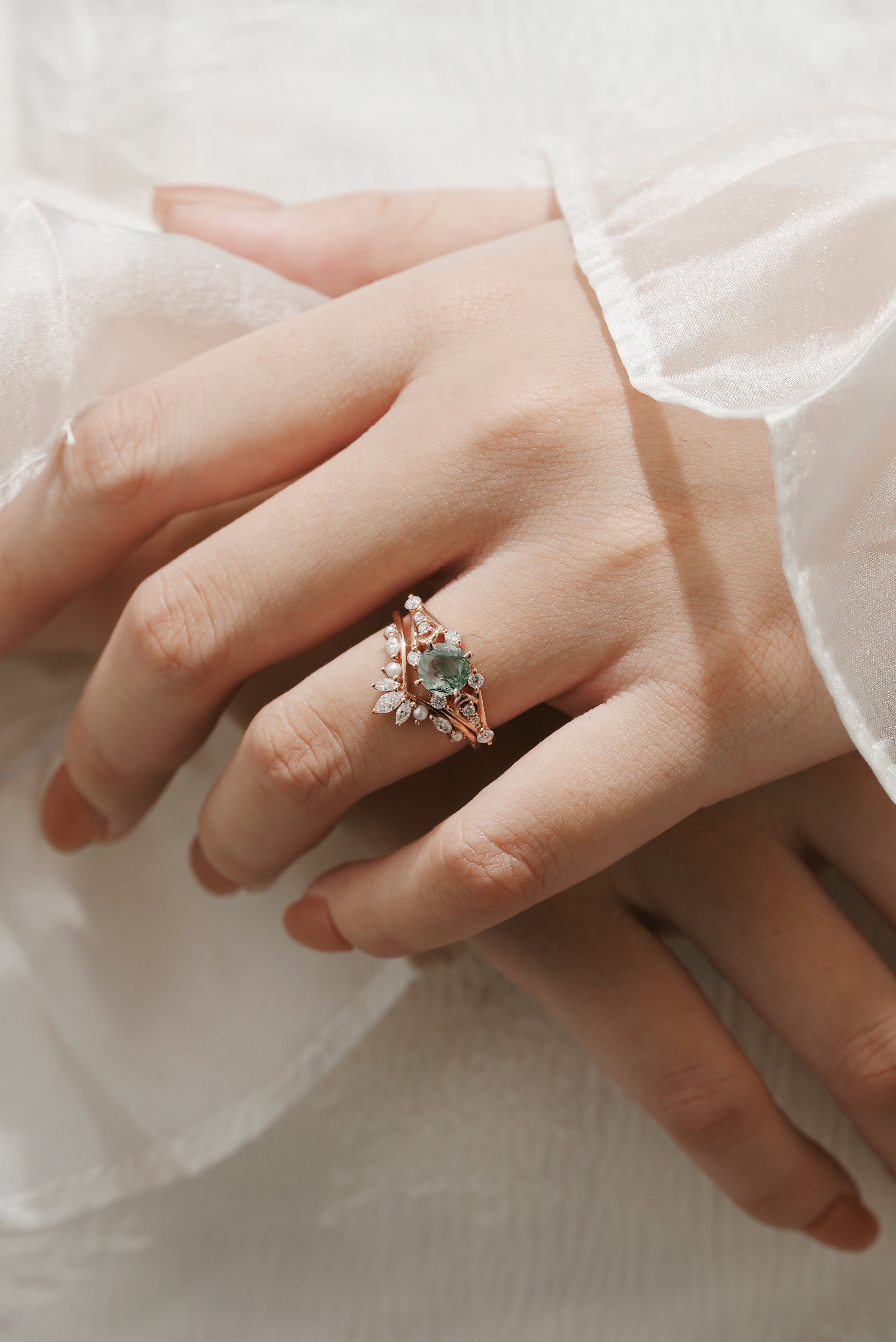 Woman's hand wearing moss agate moon engagement ring