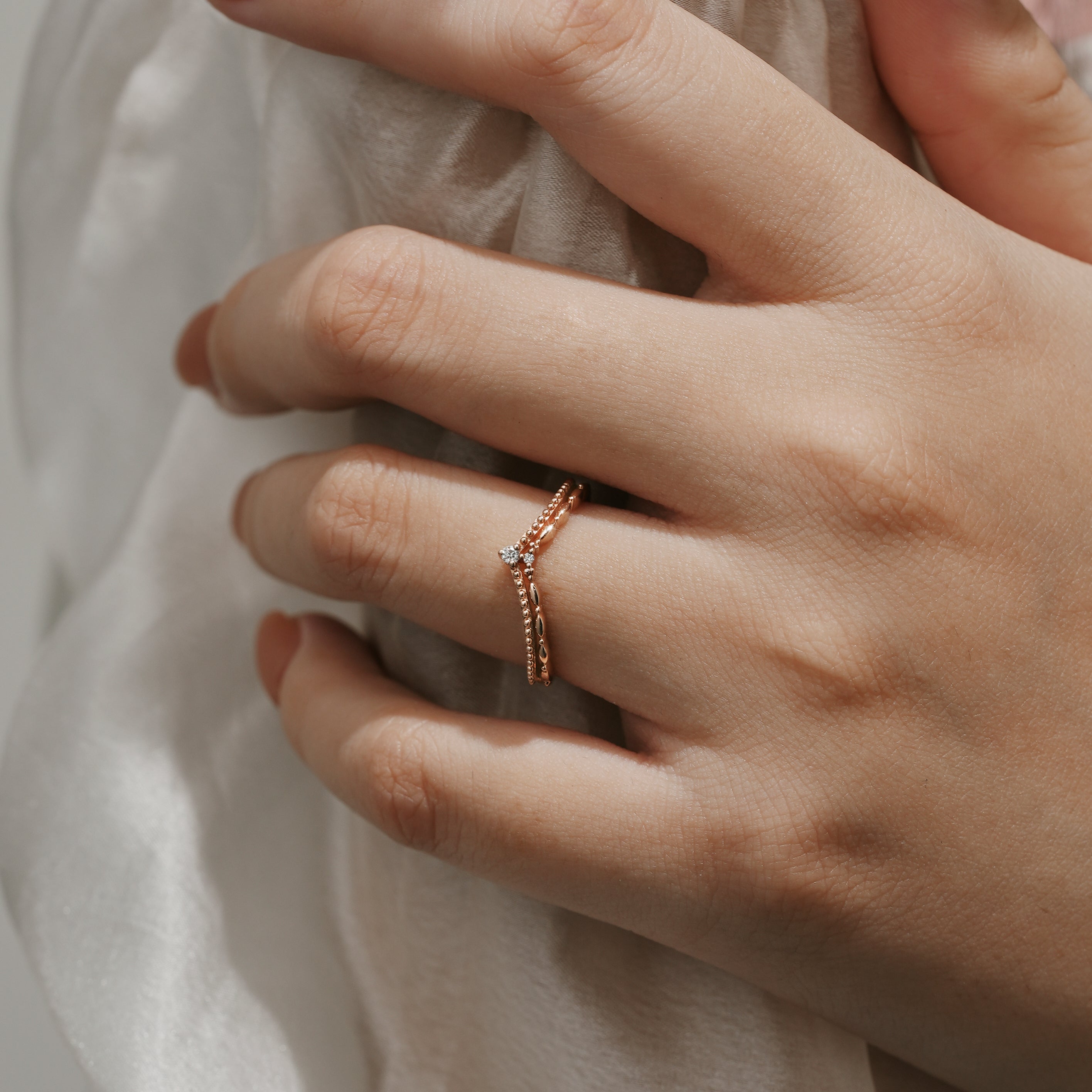 Elegant moissanite V-shaped wedding band on a woman's hand.