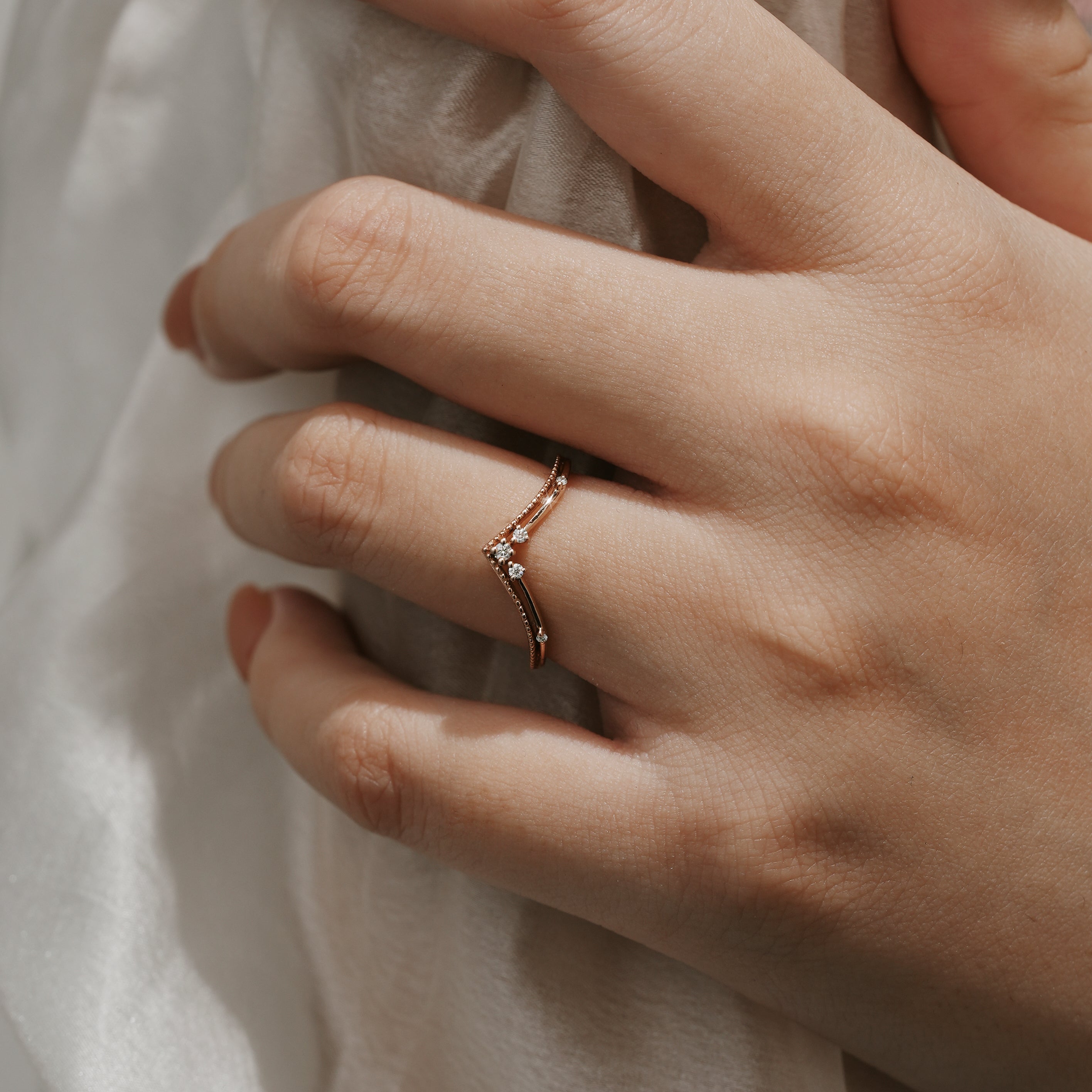 Rose gold curved moissanite wedding band on hand