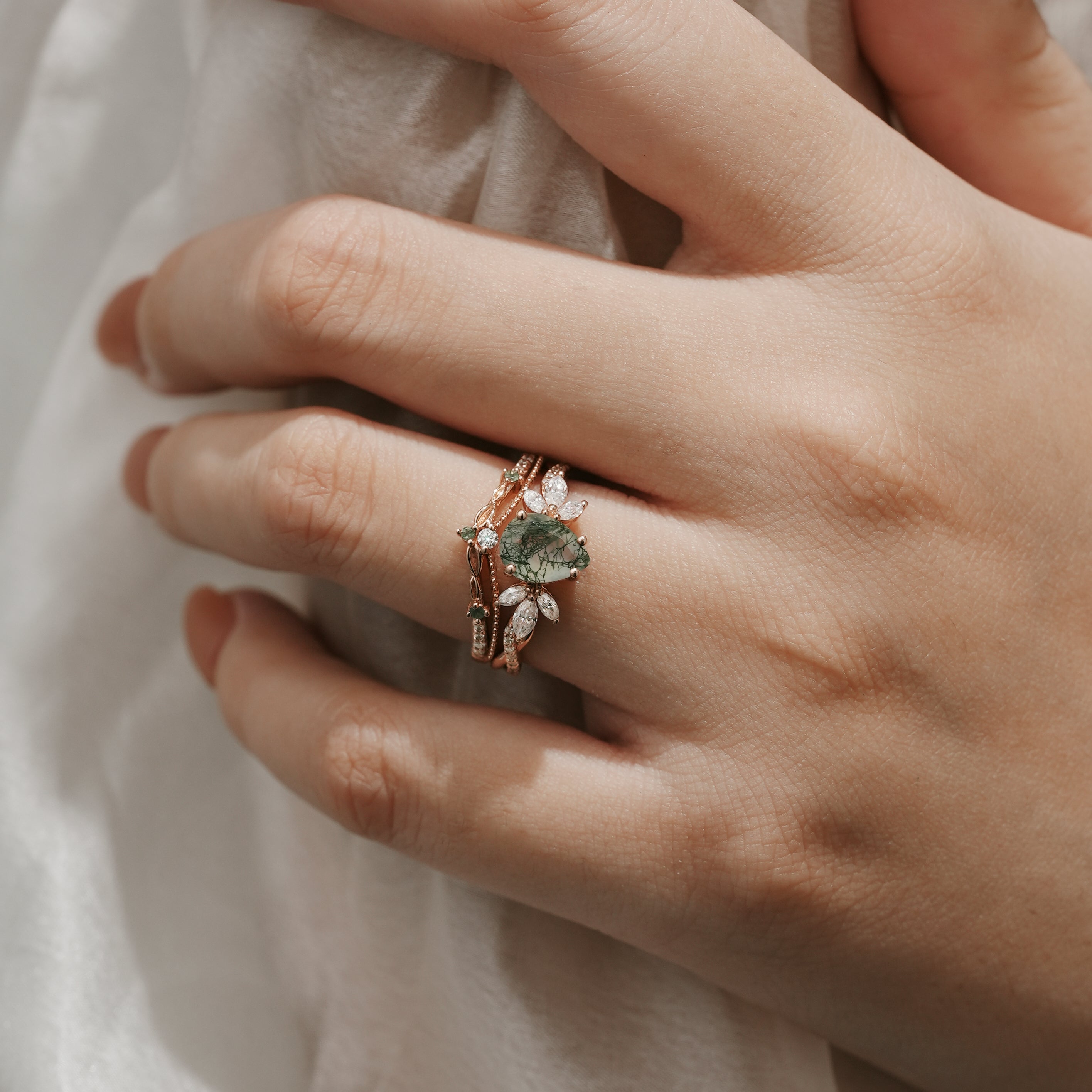 Woman wearing Pear Cut Moss Agate engagement ring set