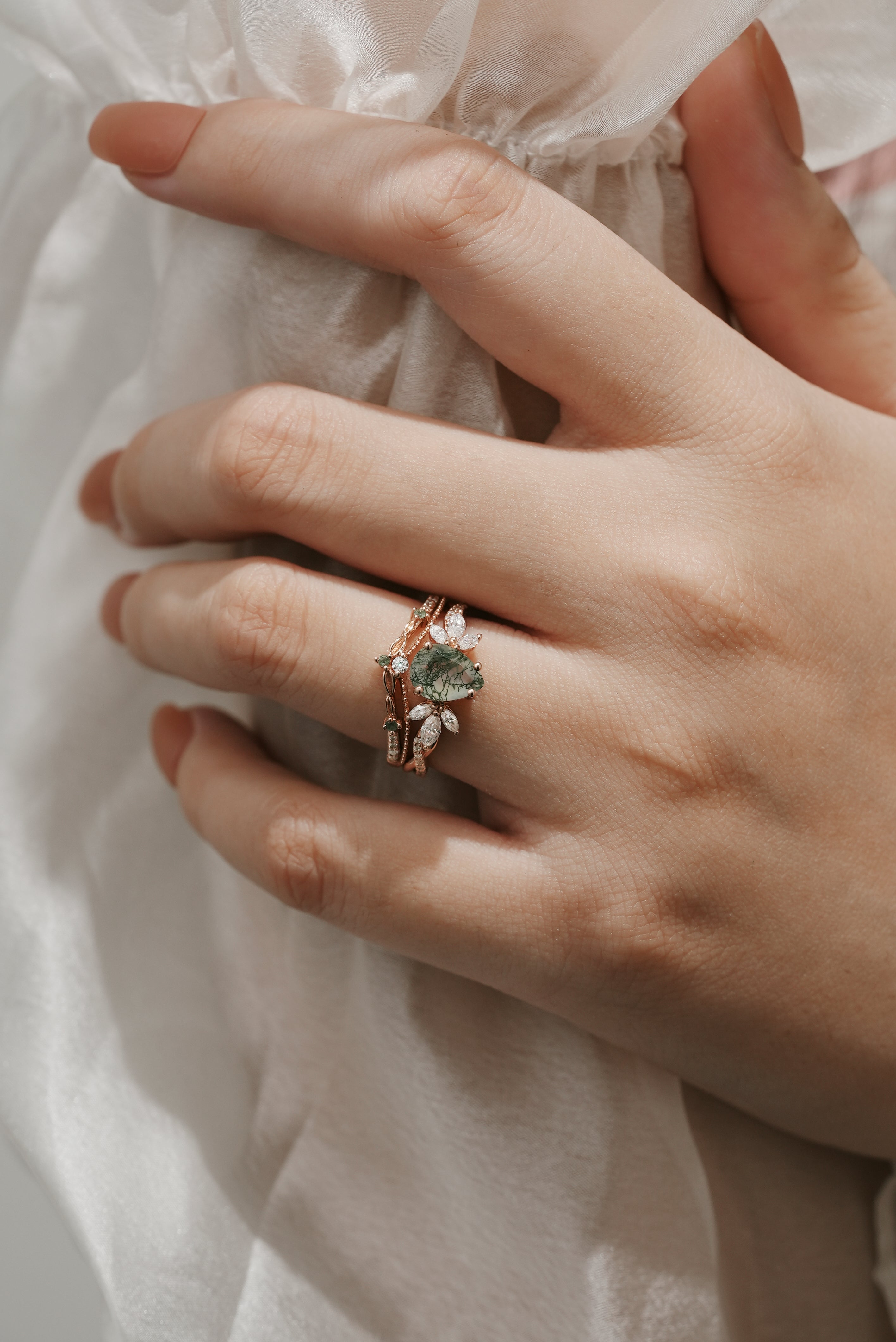 Woman wearing Pear Cut Moss Agate engagement ring set
