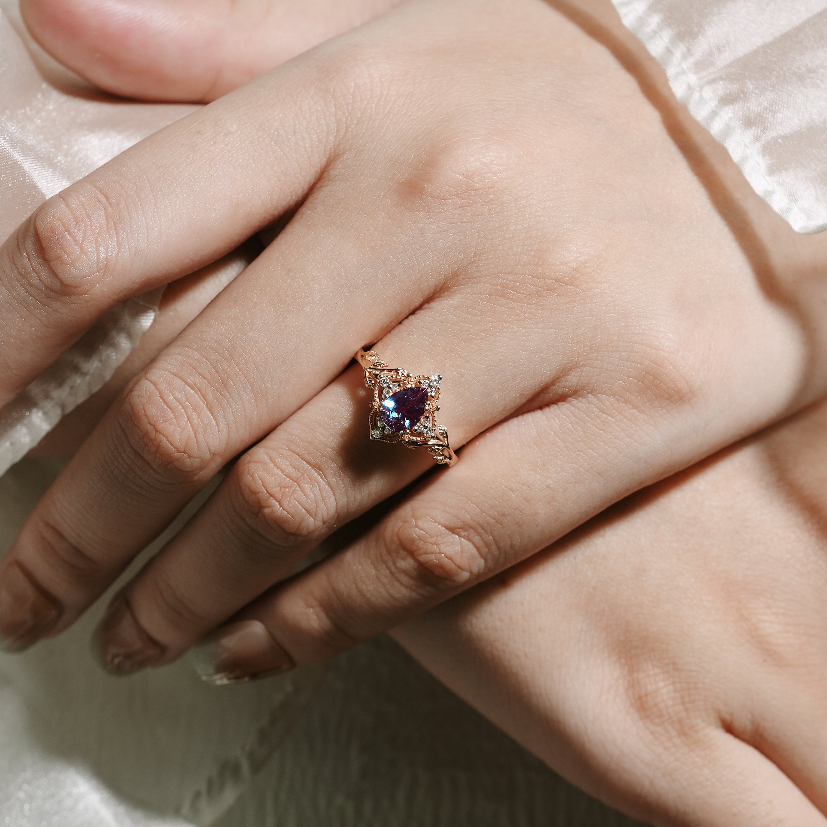 Alexandrite leaf engagement ring on a hand, pear cut
