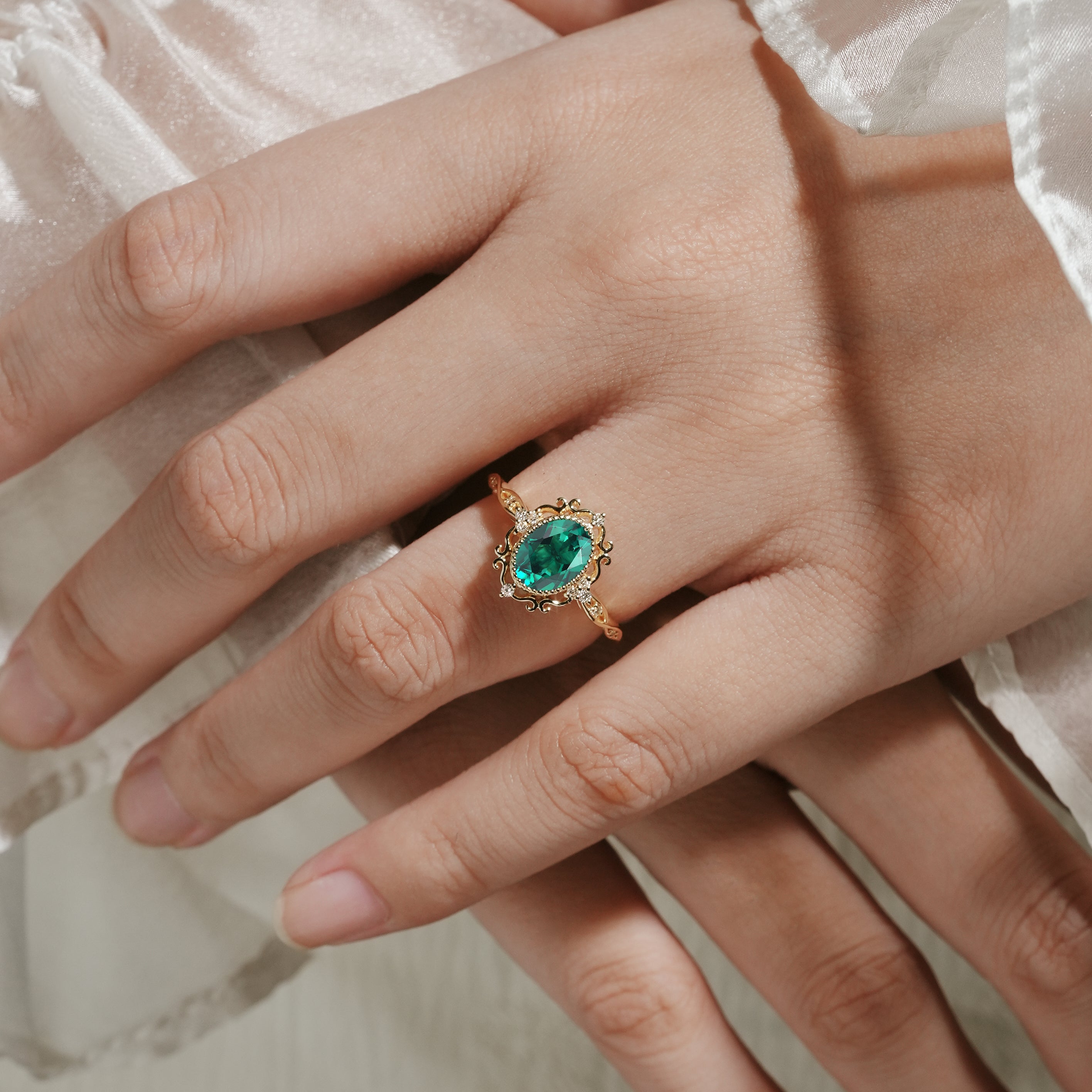 Vintage lab grown emerald engagement ring with moissanite accents, oval cut, yellow gold band, perfect for proposals.