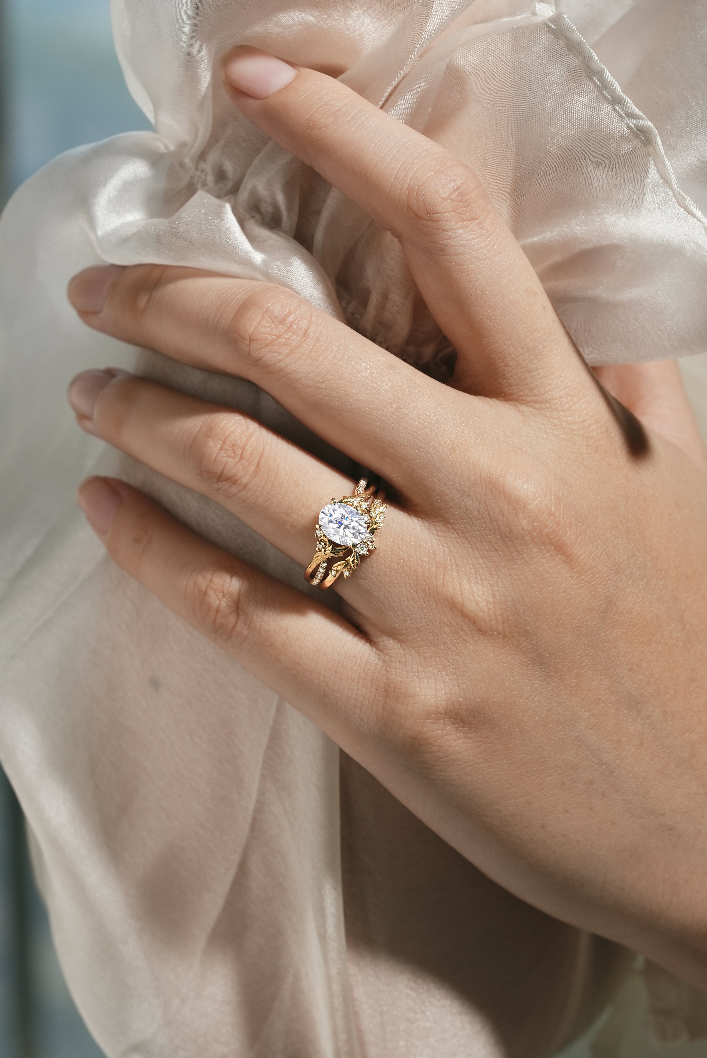 Oval moissanite engagement ring with leaf-inspired band