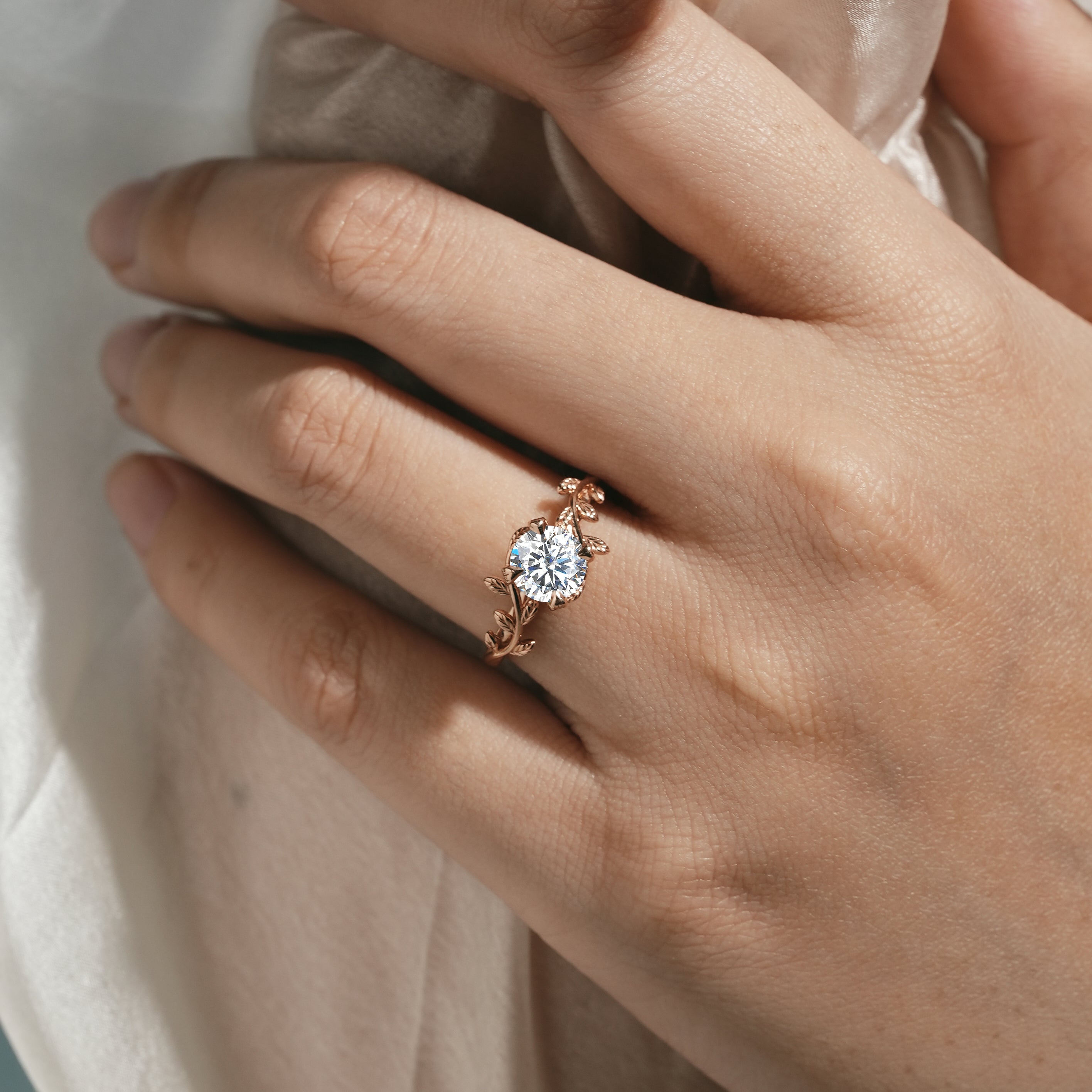 Rose gold leaf engagement ring on a hand