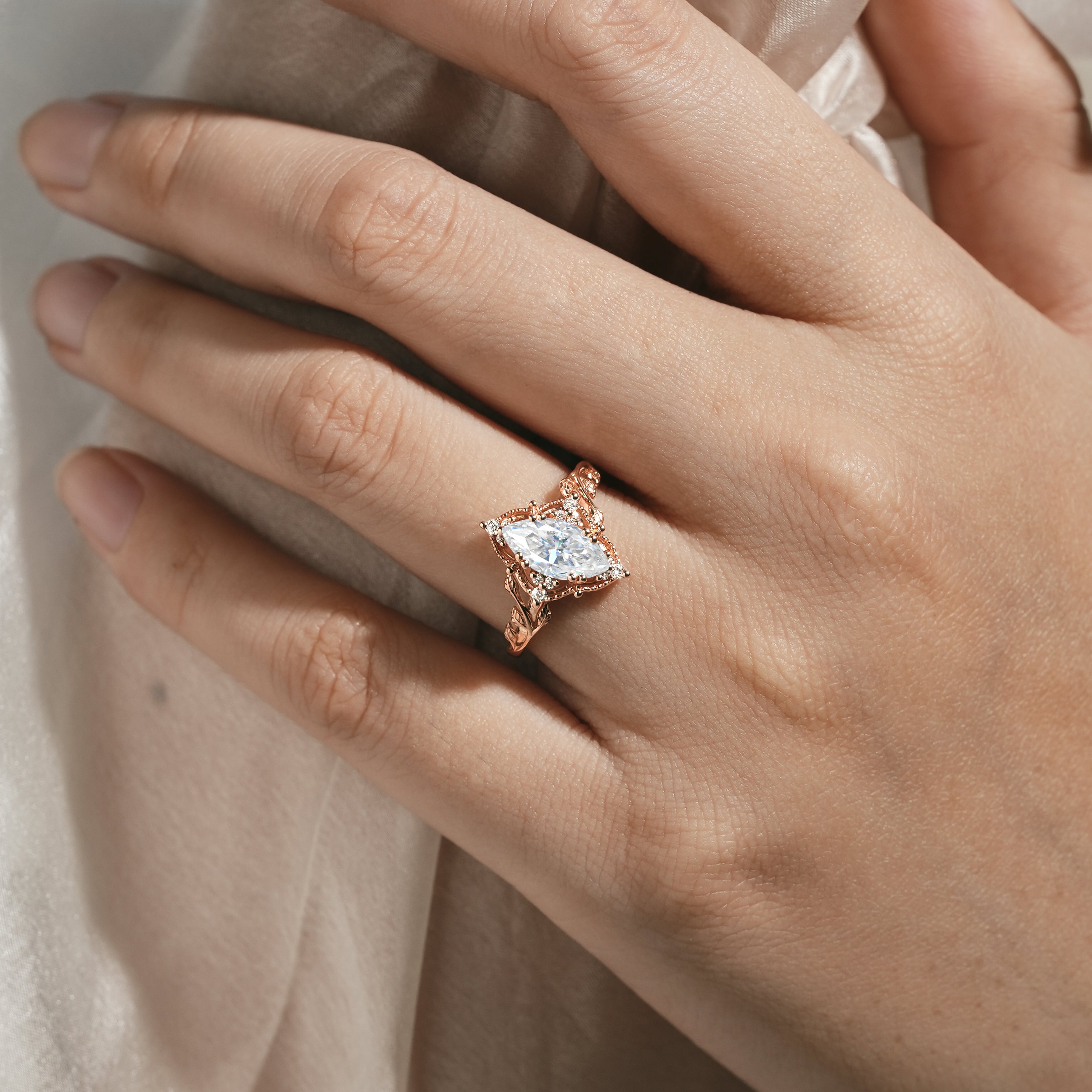 Marquise moissanite ring with leaf details, rose gold band, nature-inspired design