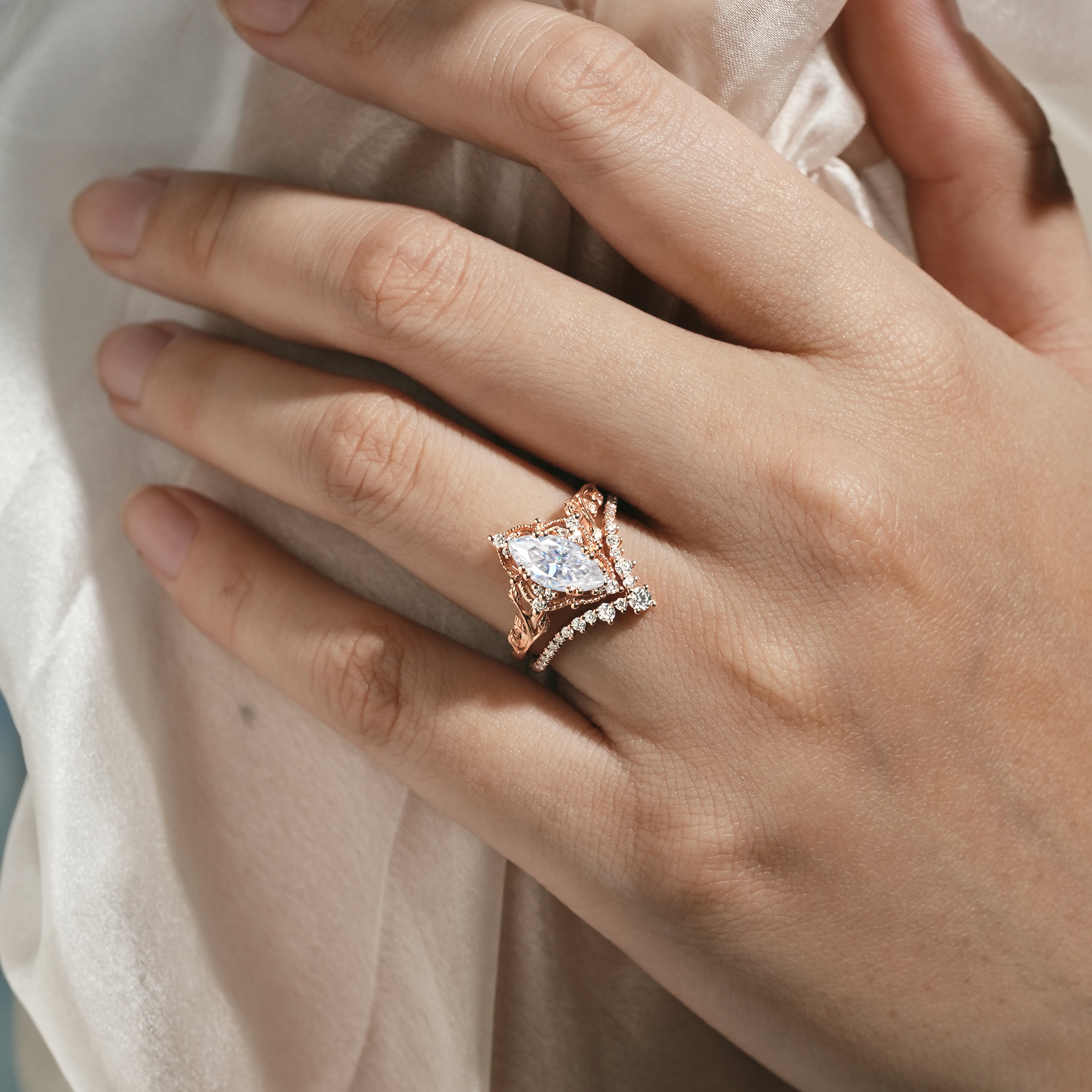 Rose gold marquise moissanite engagement ring with leaf design and curved wedding band