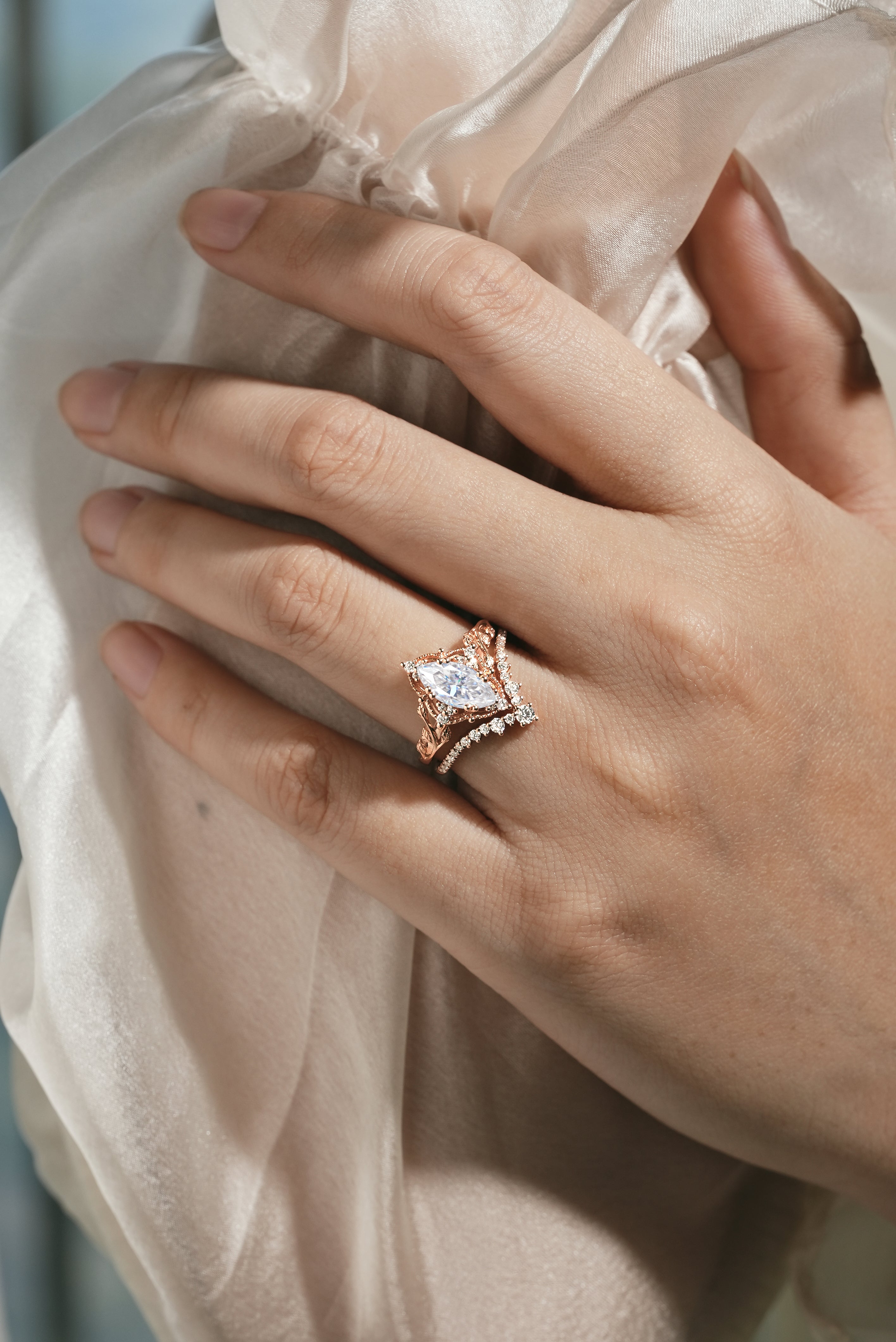 Rose gold marquise moissanite engagement ring with leaf design and curved wedding band