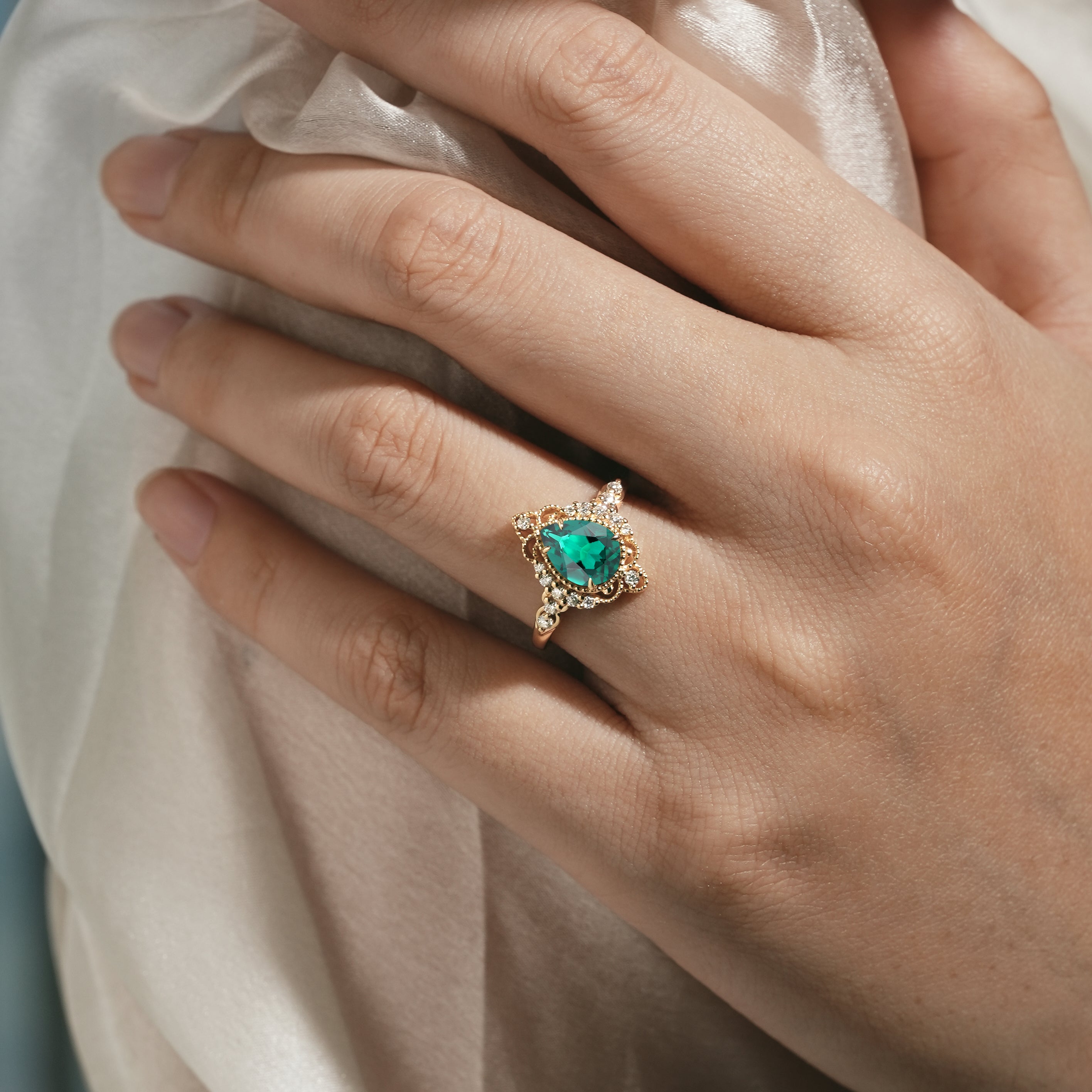 Emerald engagement ring on a hand, vintage design, palace style