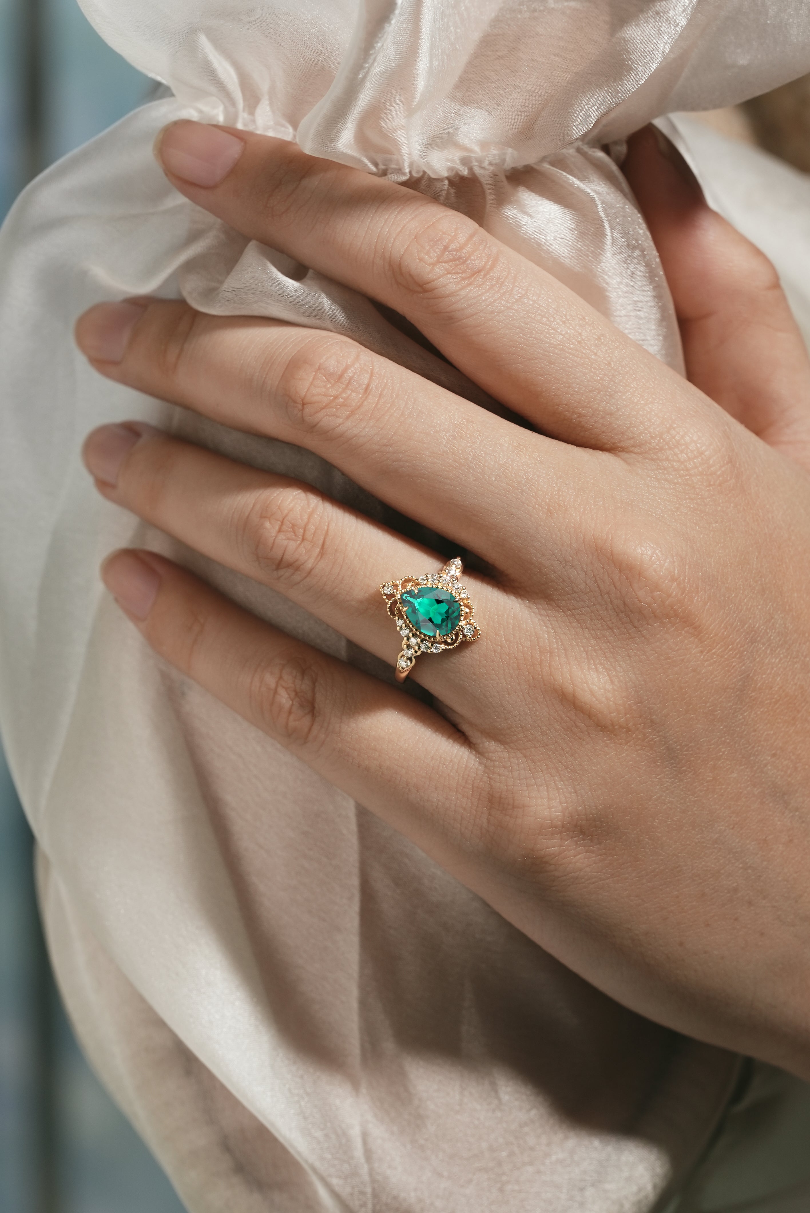 Emerald engagement ring on a hand, vintage design, palace style
