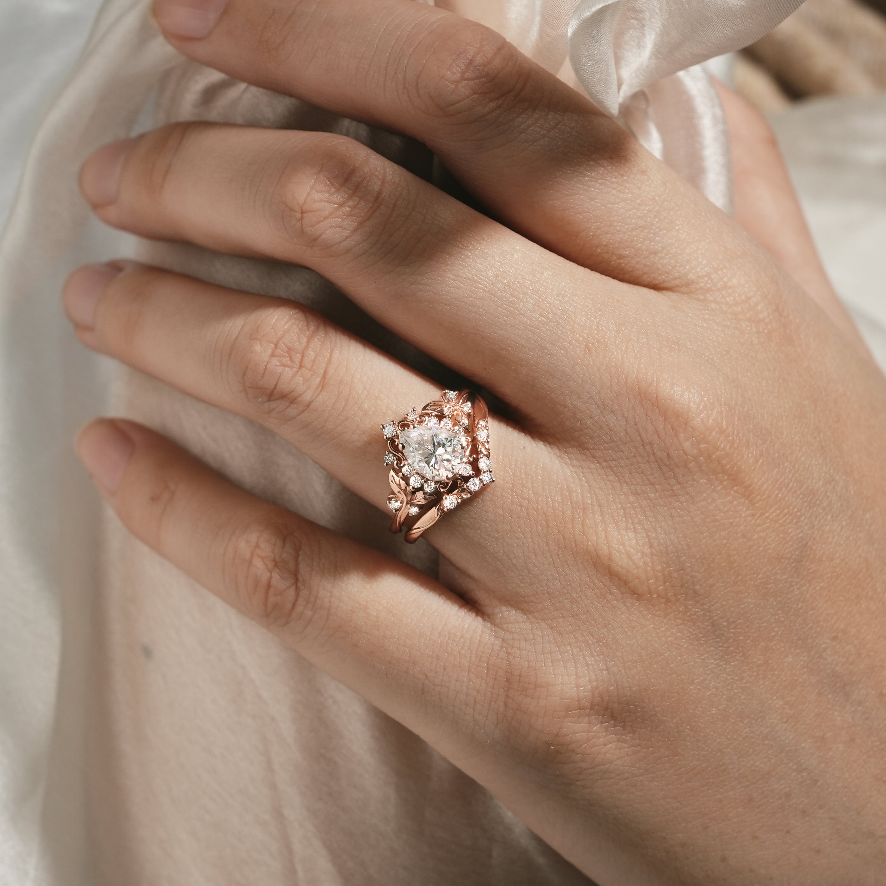 Woman's hand wearing moissanite leaf engagement ring set