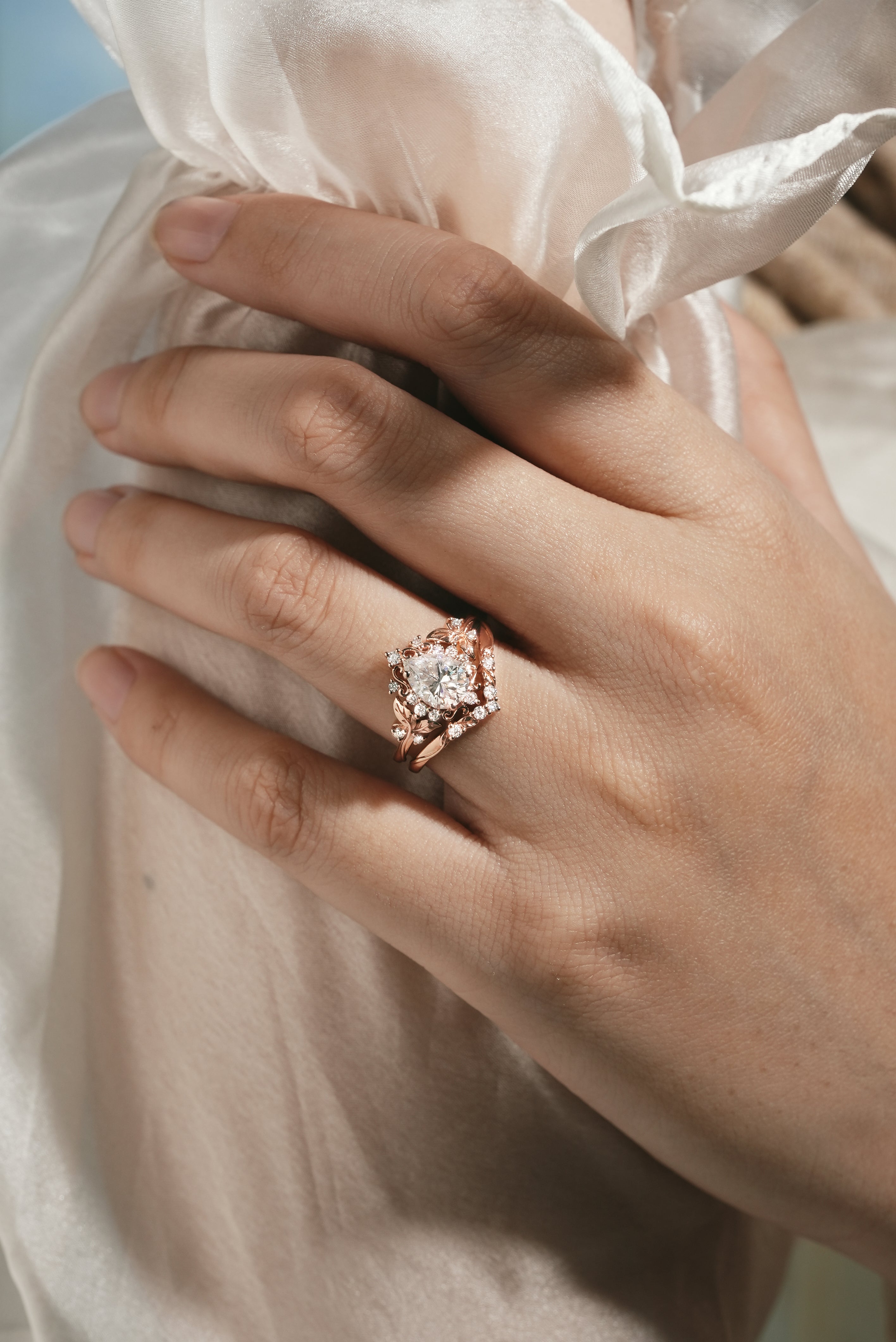 Woman's hand wearing moissanite leaf engagement ring set