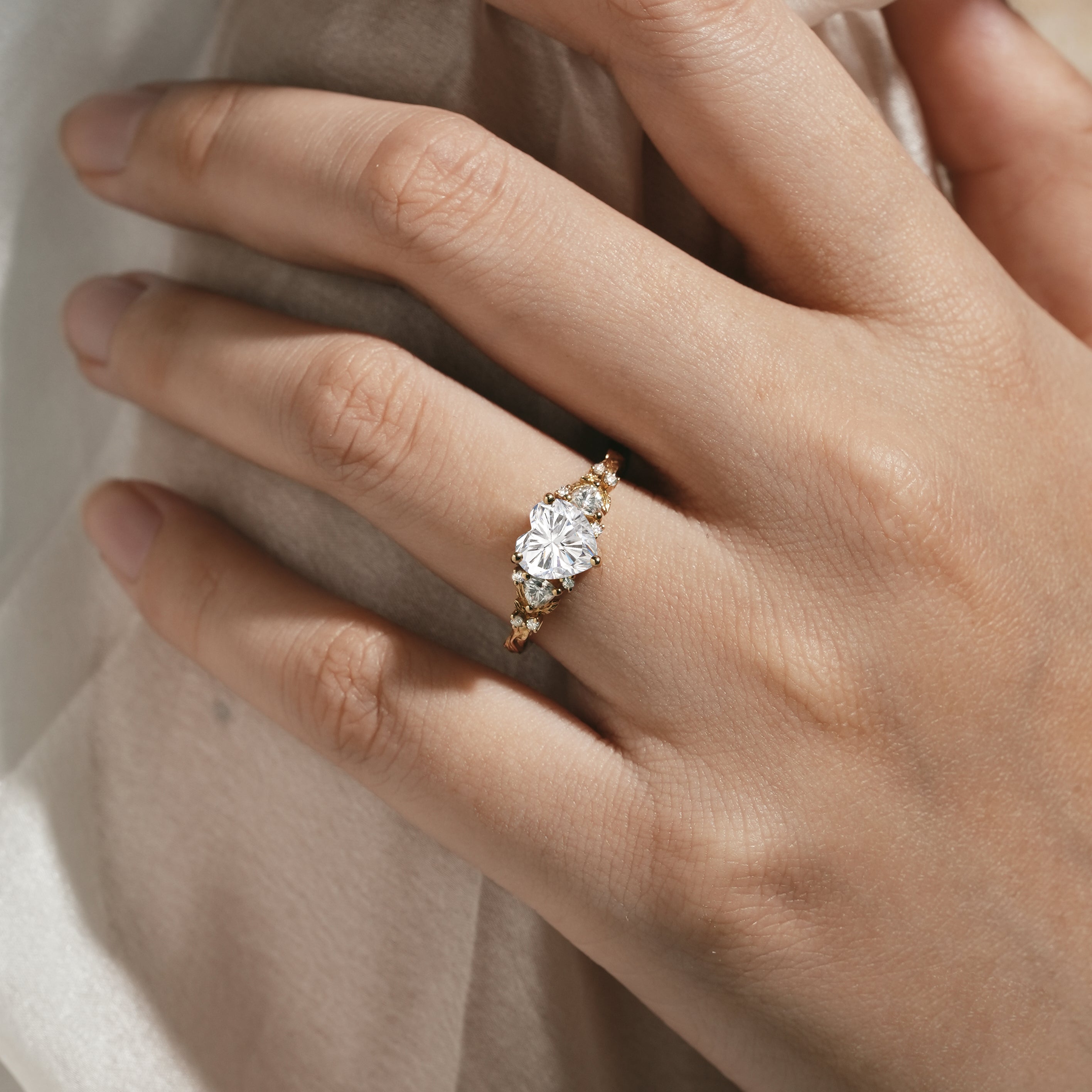 Woman's hand wearing leaf-design moissanite engagement ring