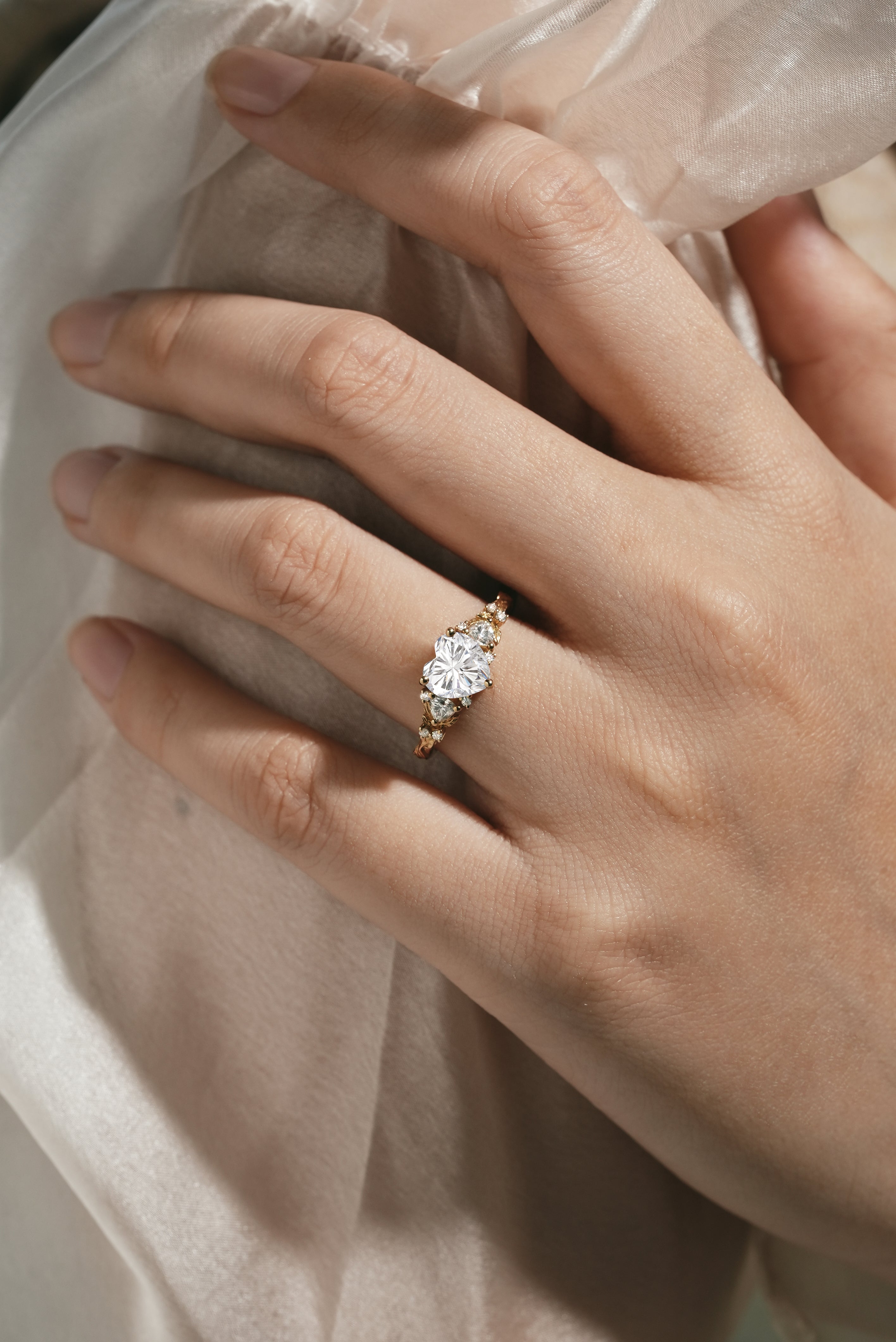 Woman's hand wearing leaf-design moissanite engagement ring