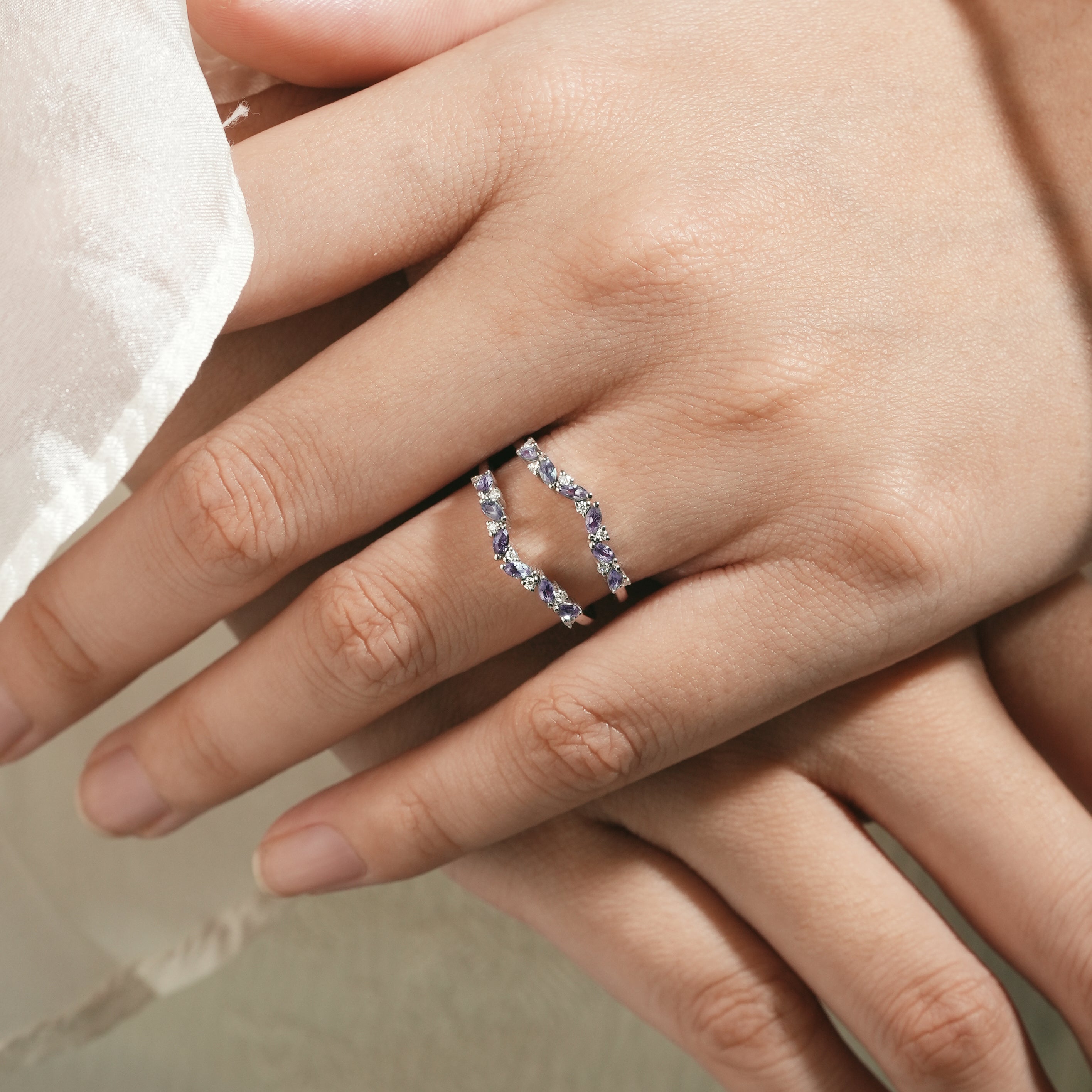 Alexandrite enhancer wedding band on a hand. Sterling silver bridal set with moissanite.