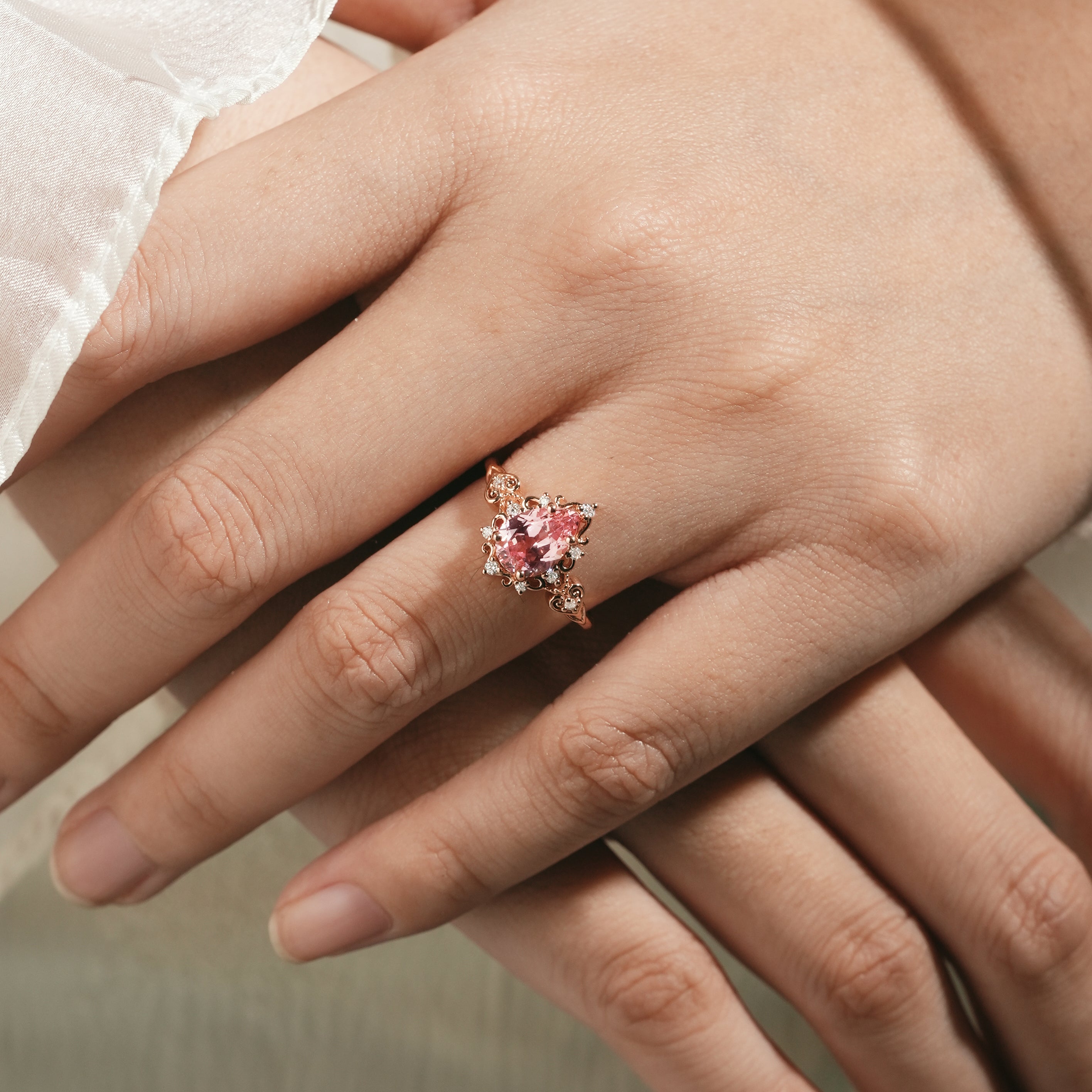 Rose gold Padparadscha sapphire engagement ring on hand