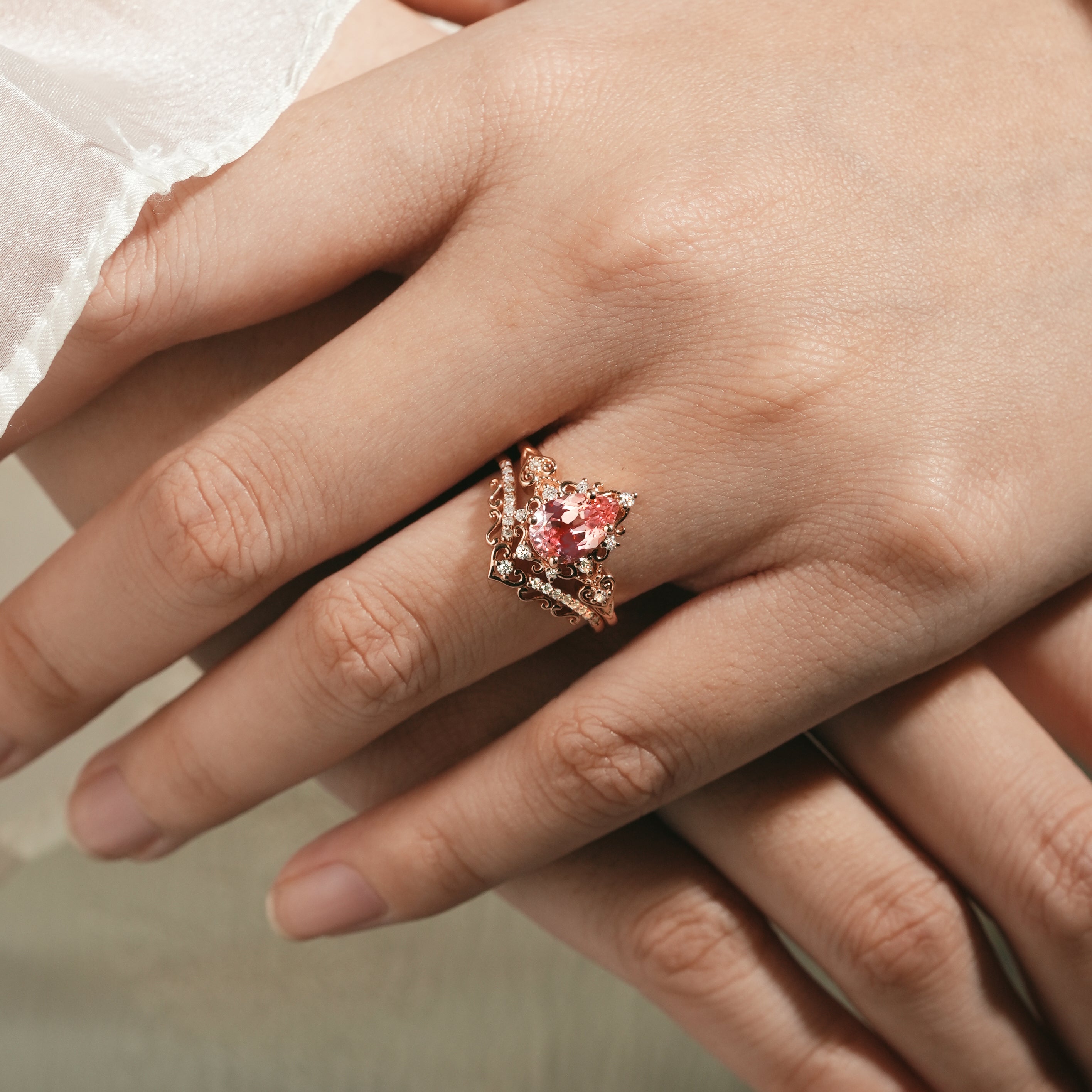 Rose gold engagement ring with Padparadscha sapphire on hand