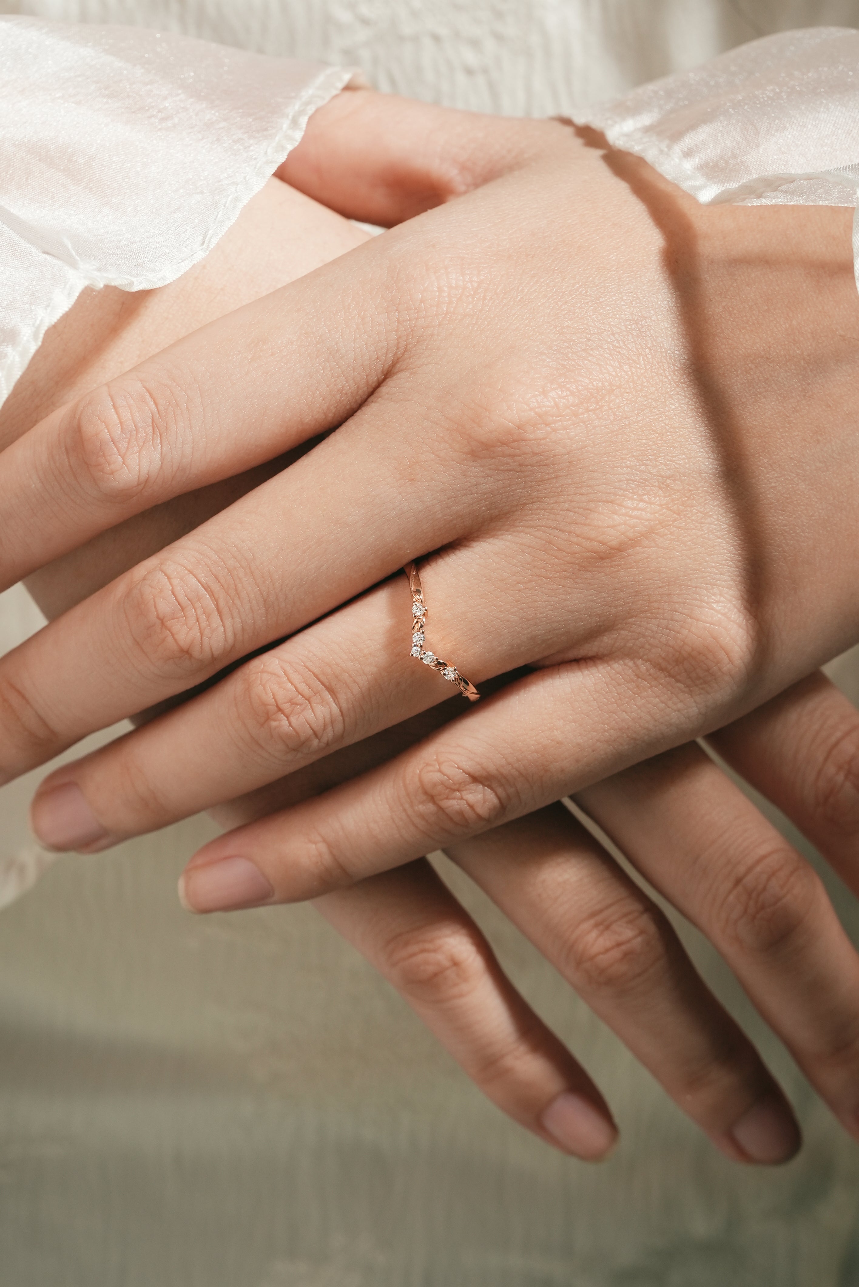 Woman's hand wearing a V-shaped moissanite wedding band