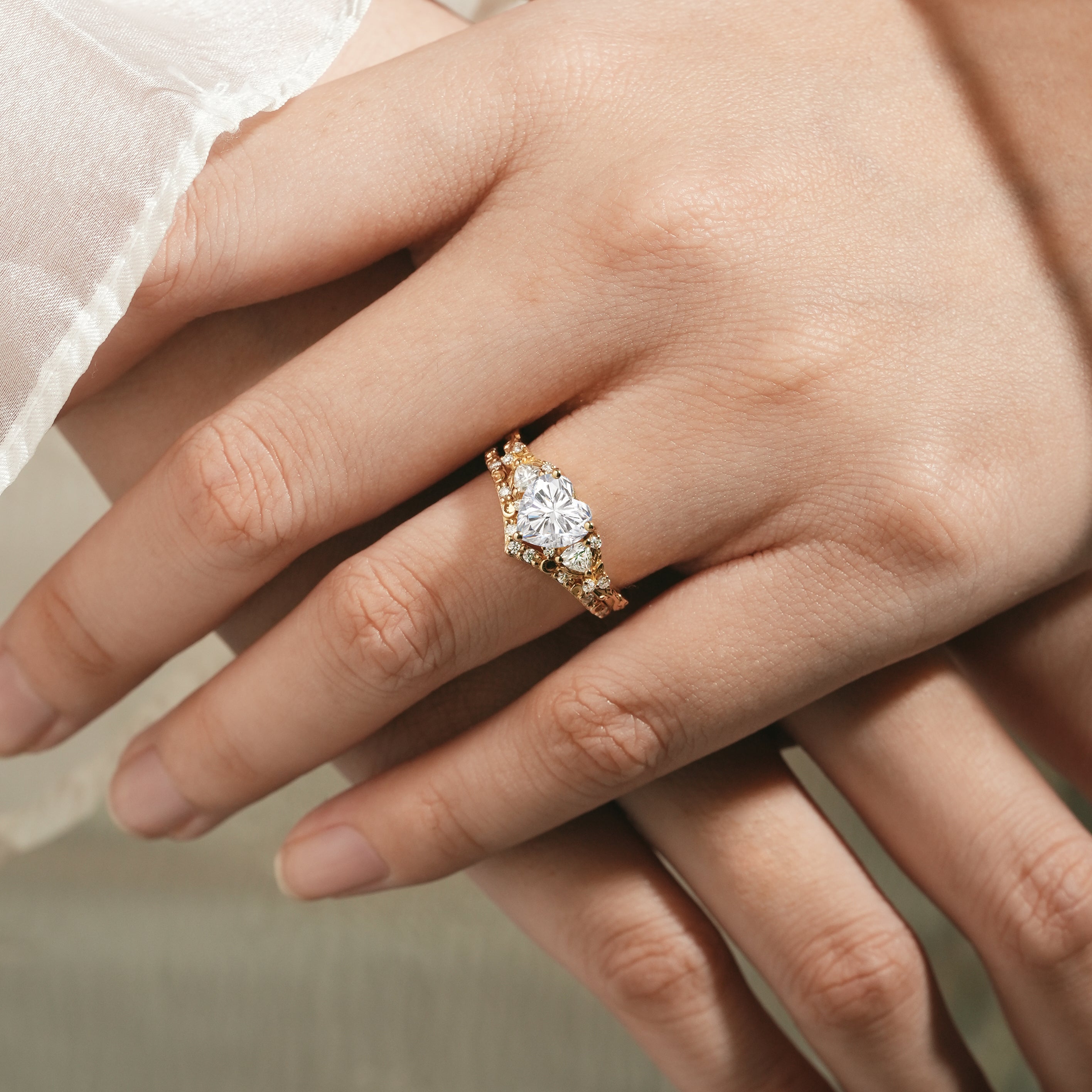 Heart-cut moissanite ring with leaf design on woman's hand