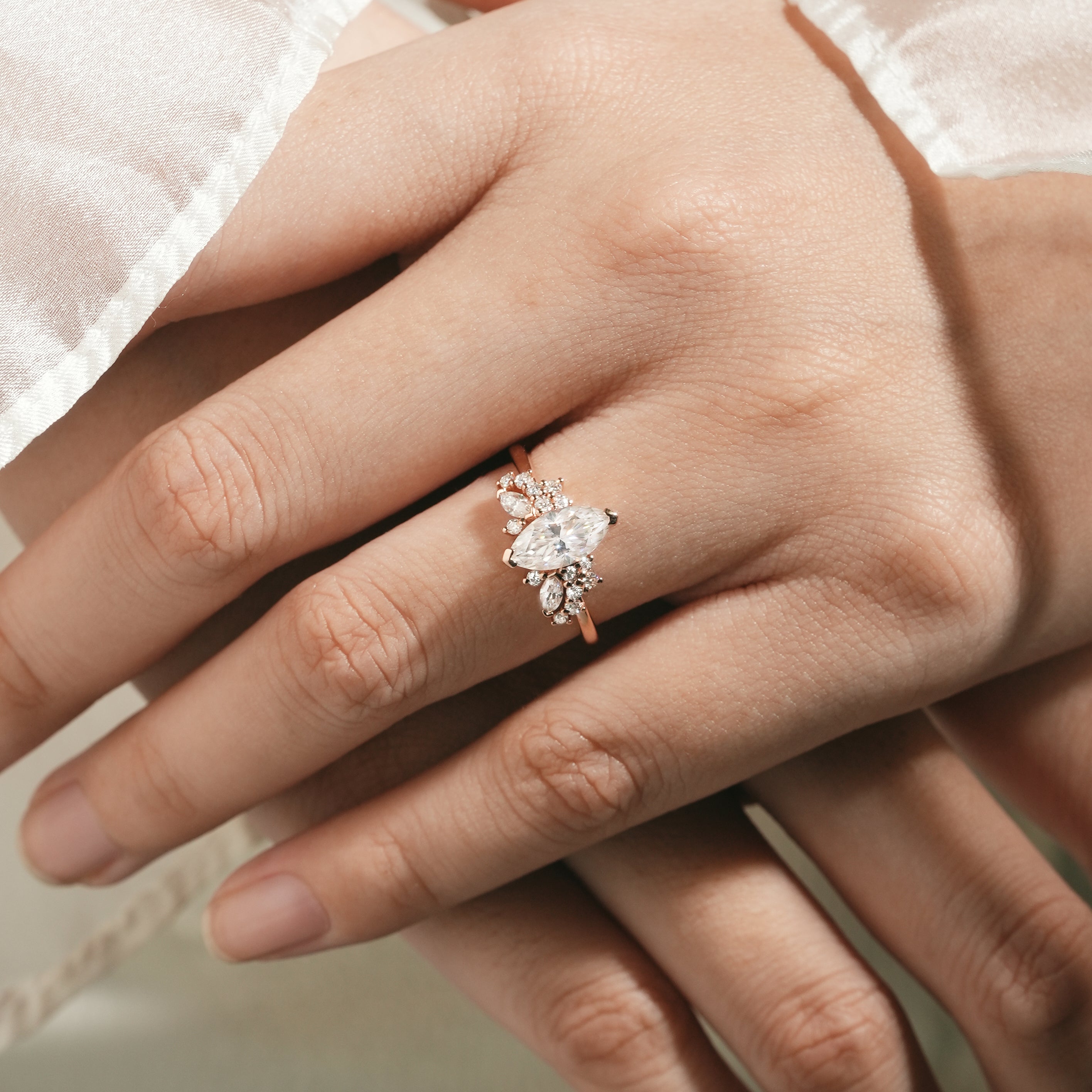 Rose gold marquise moissanite cluster engagement ring on hand
