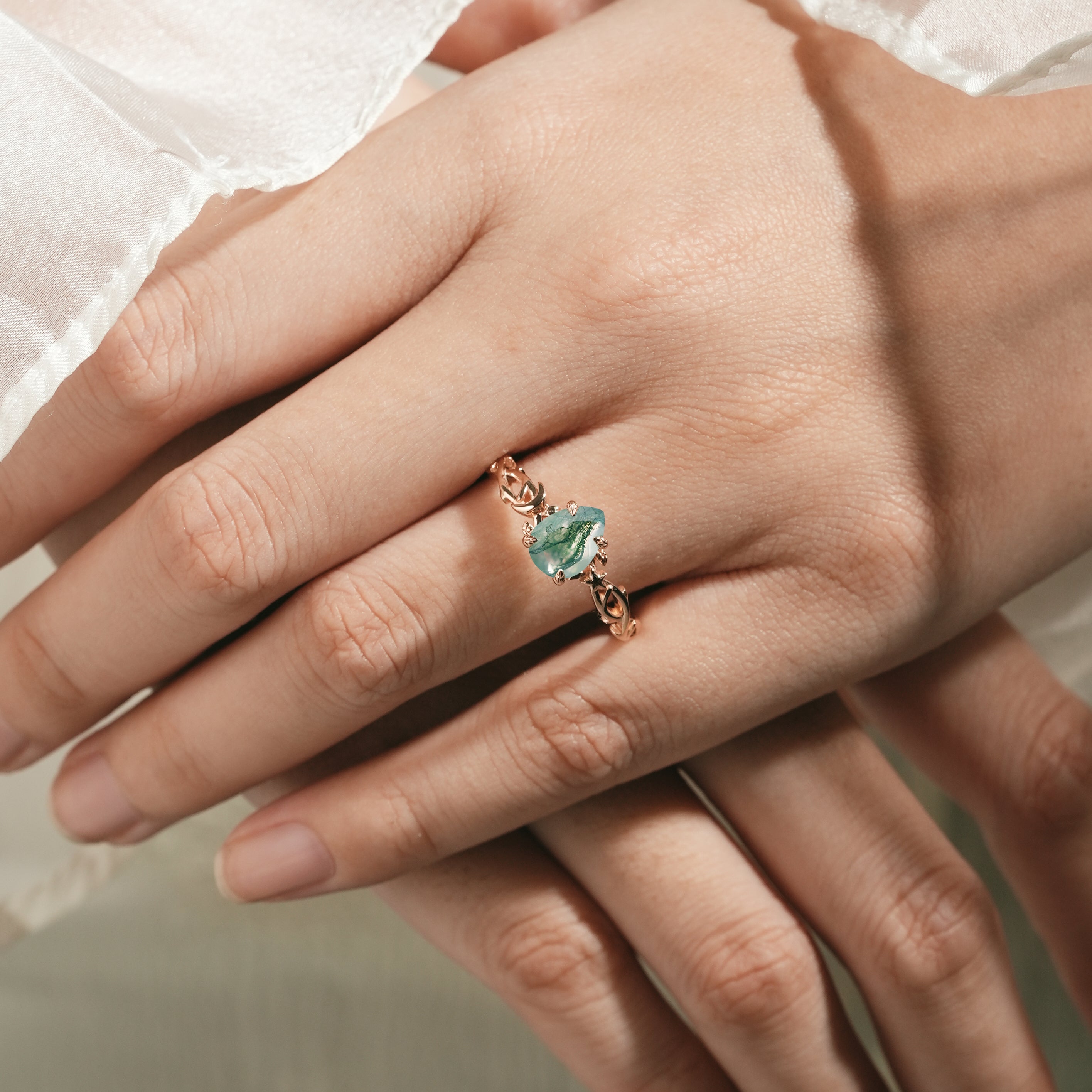 Moss Agate Pear Cut Engagement Ring on hand, nature-inspired design