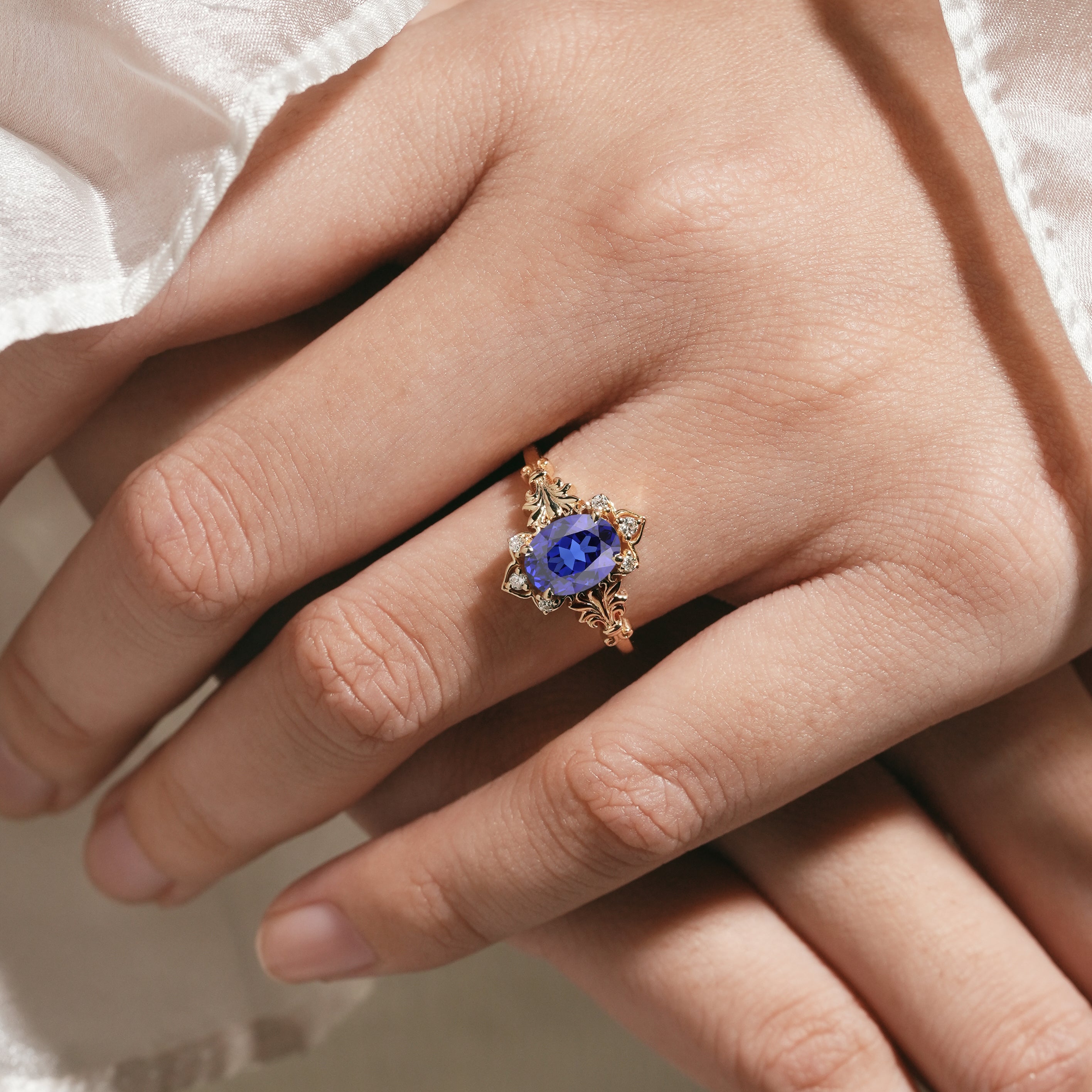 Woman's hand with oval royal blue sapphire engagement ring