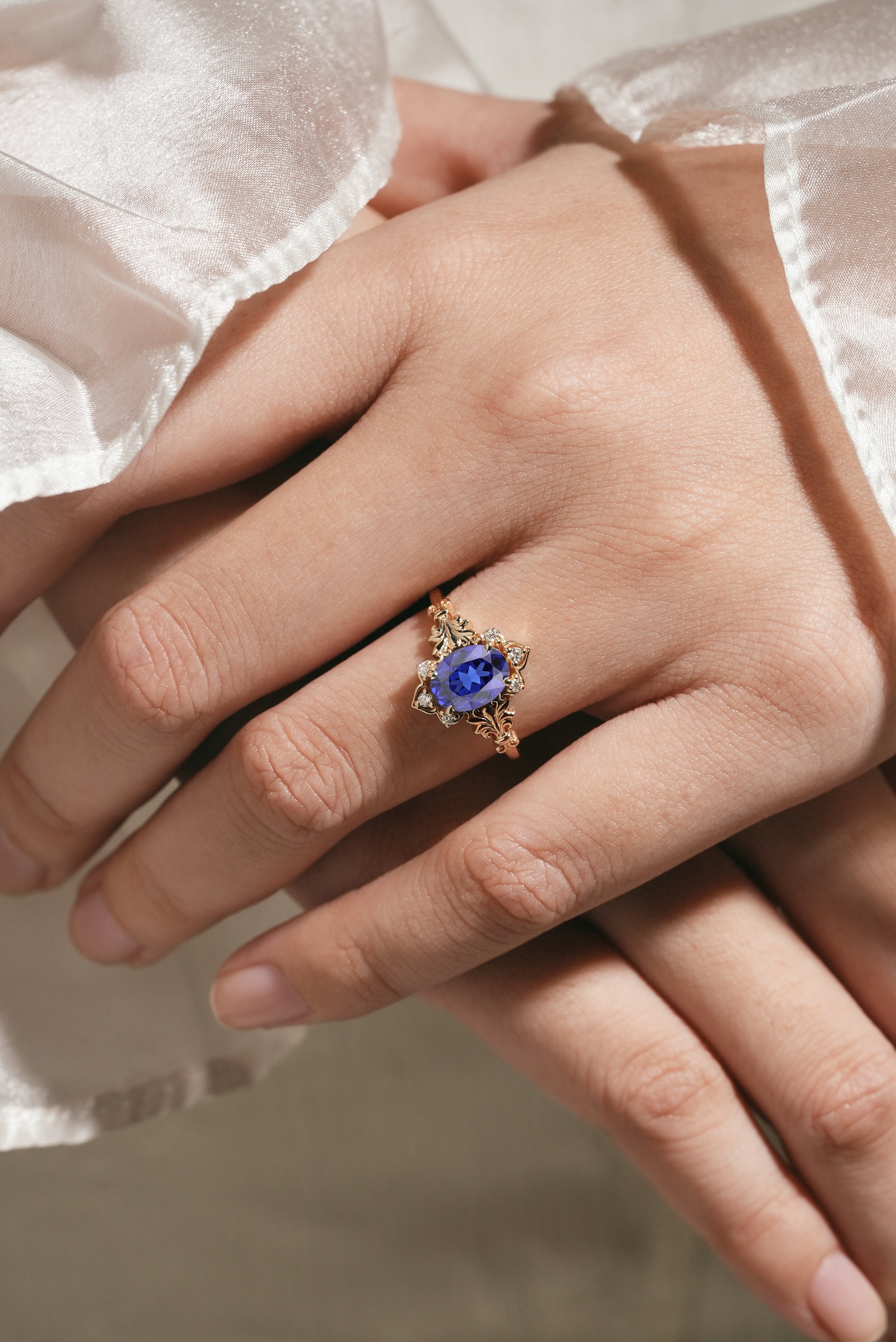 Woman's hand with oval royal blue sapphire engagement ring