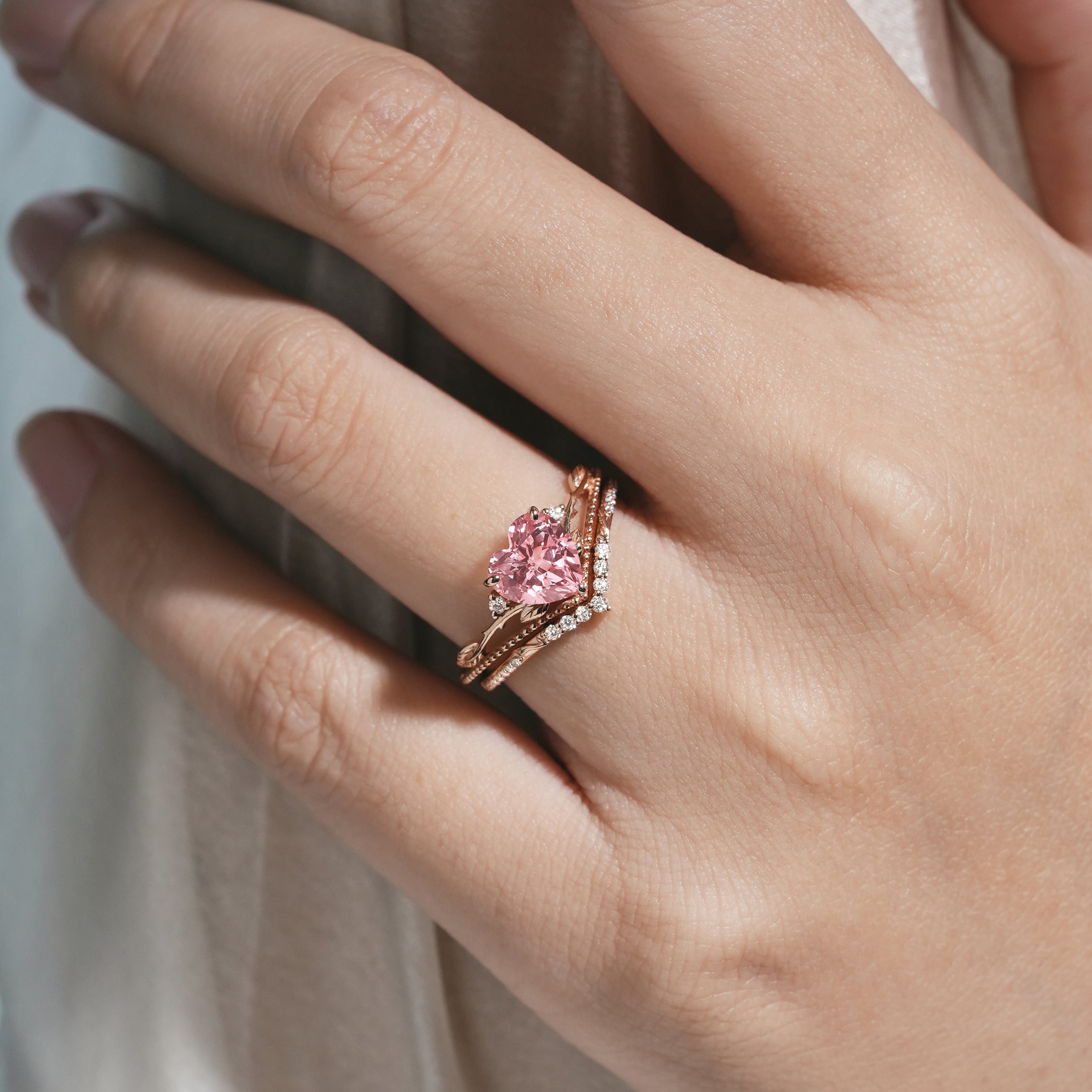 Rose gold heart-cut engagement ring with leaf design and Padparadscha sapphire