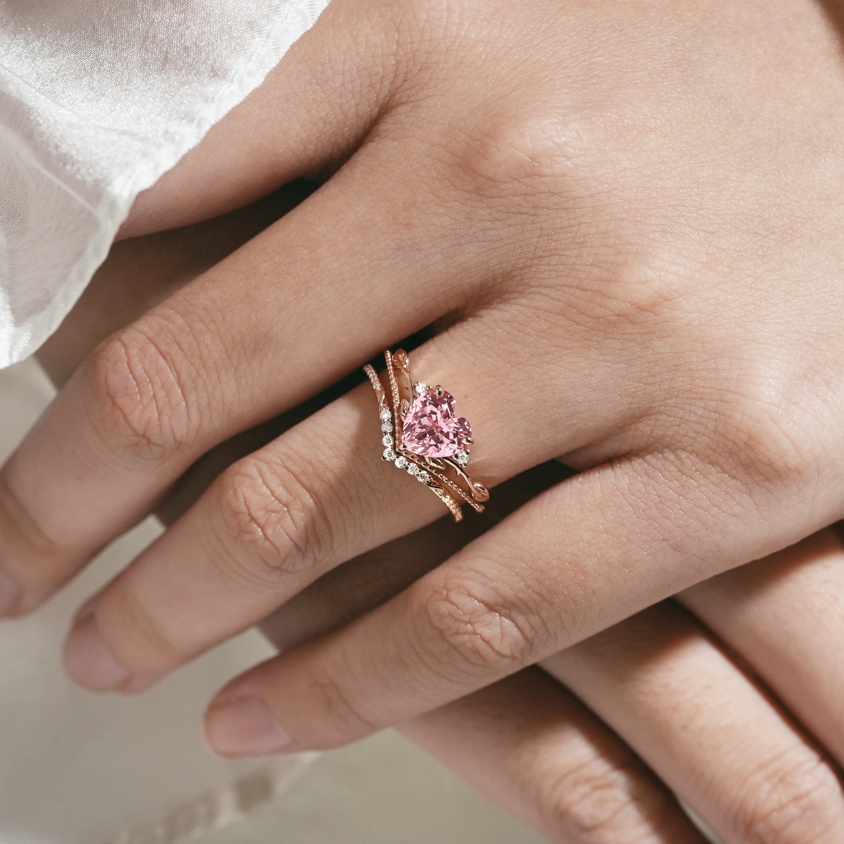 Heart-cut Padparadscha sapphire ring set on hand, leaf design