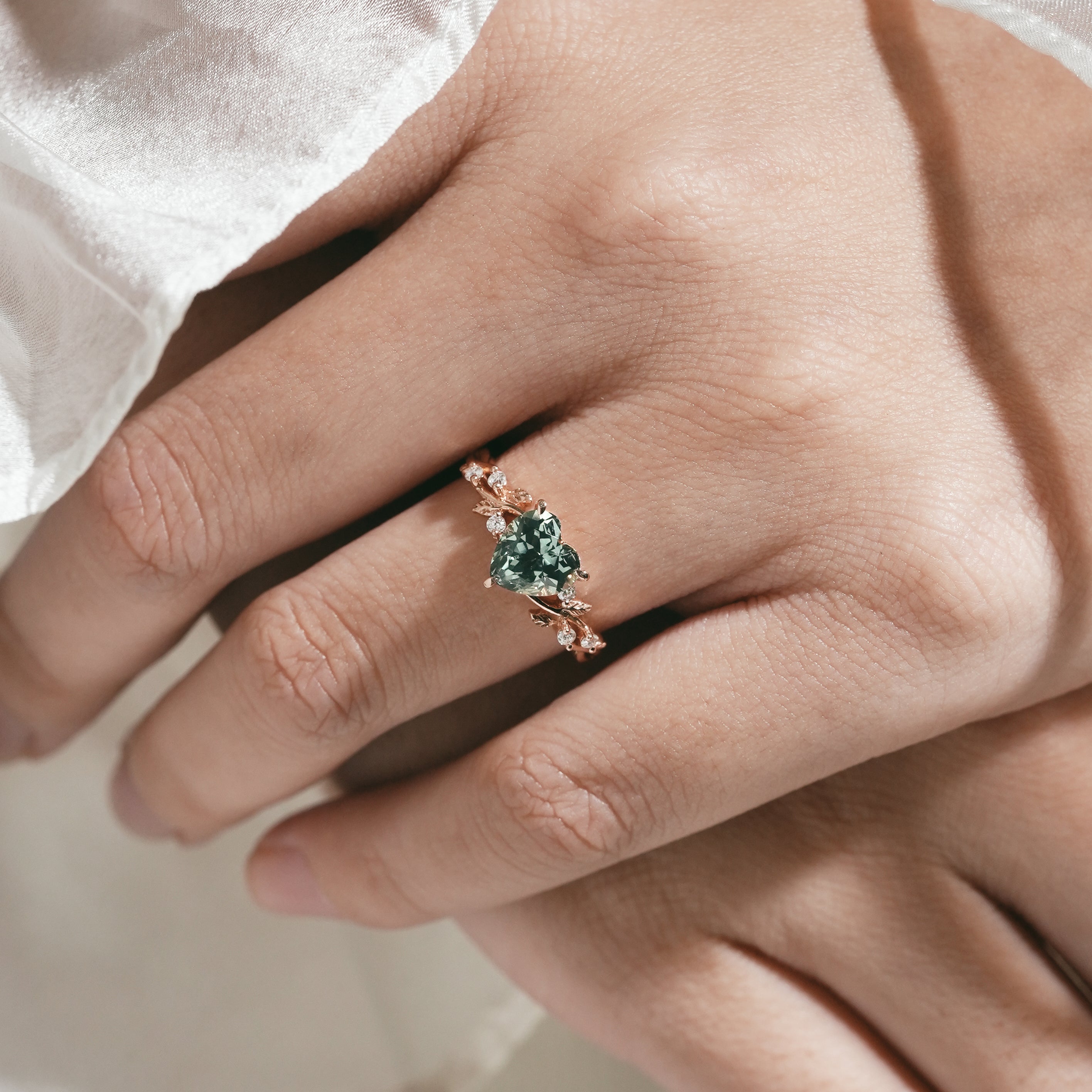 Woman's hand wearing green sapphire engagement ring, Lahela Jewelry
