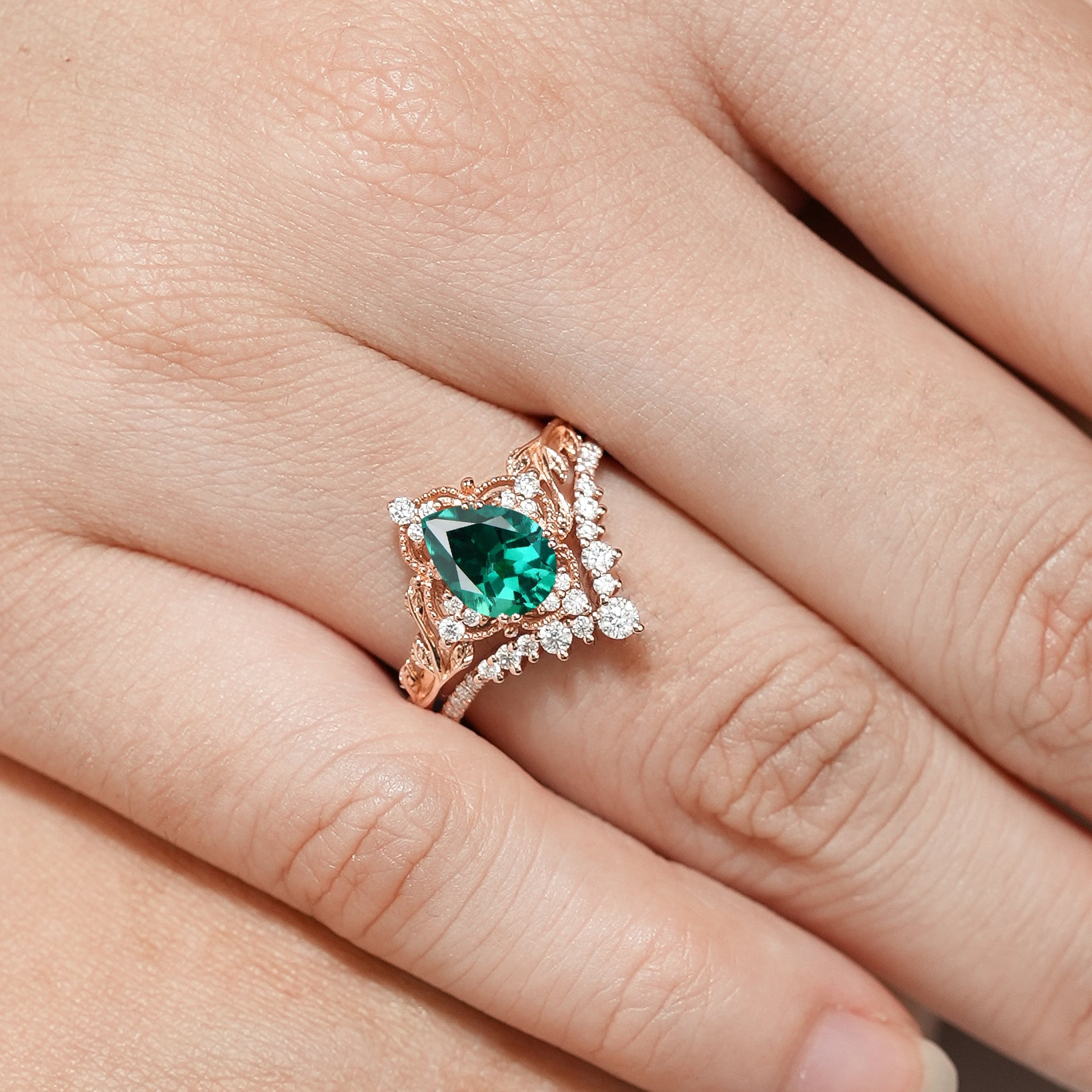 Rose gold pear cut lab emerald leaf engagement ring