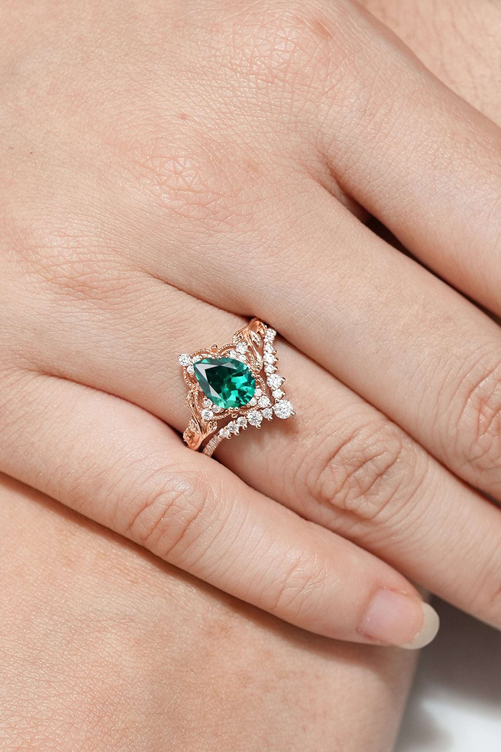 Rose gold pear cut lab emerald leaf engagement ring
