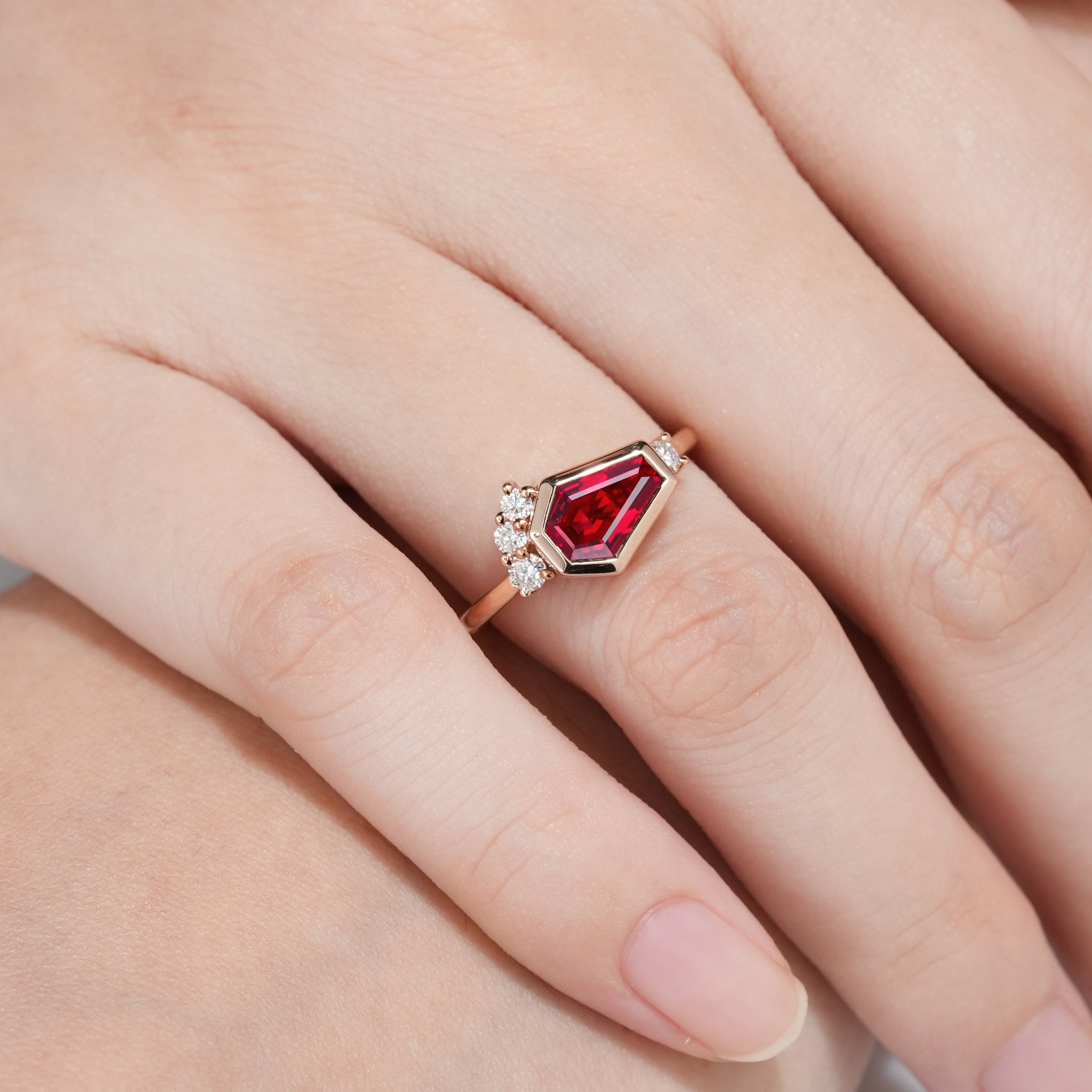 Hand wearing unique coffin cut ruby engagement ring