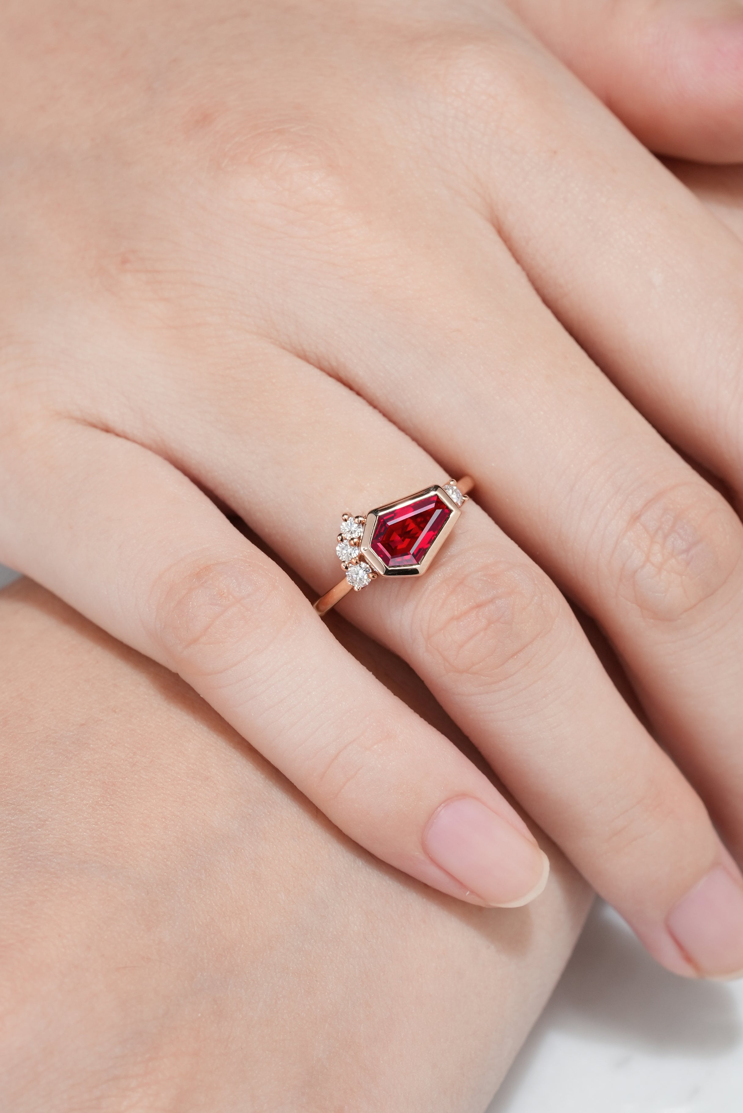 Hand wearing unique coffin cut ruby engagement ring