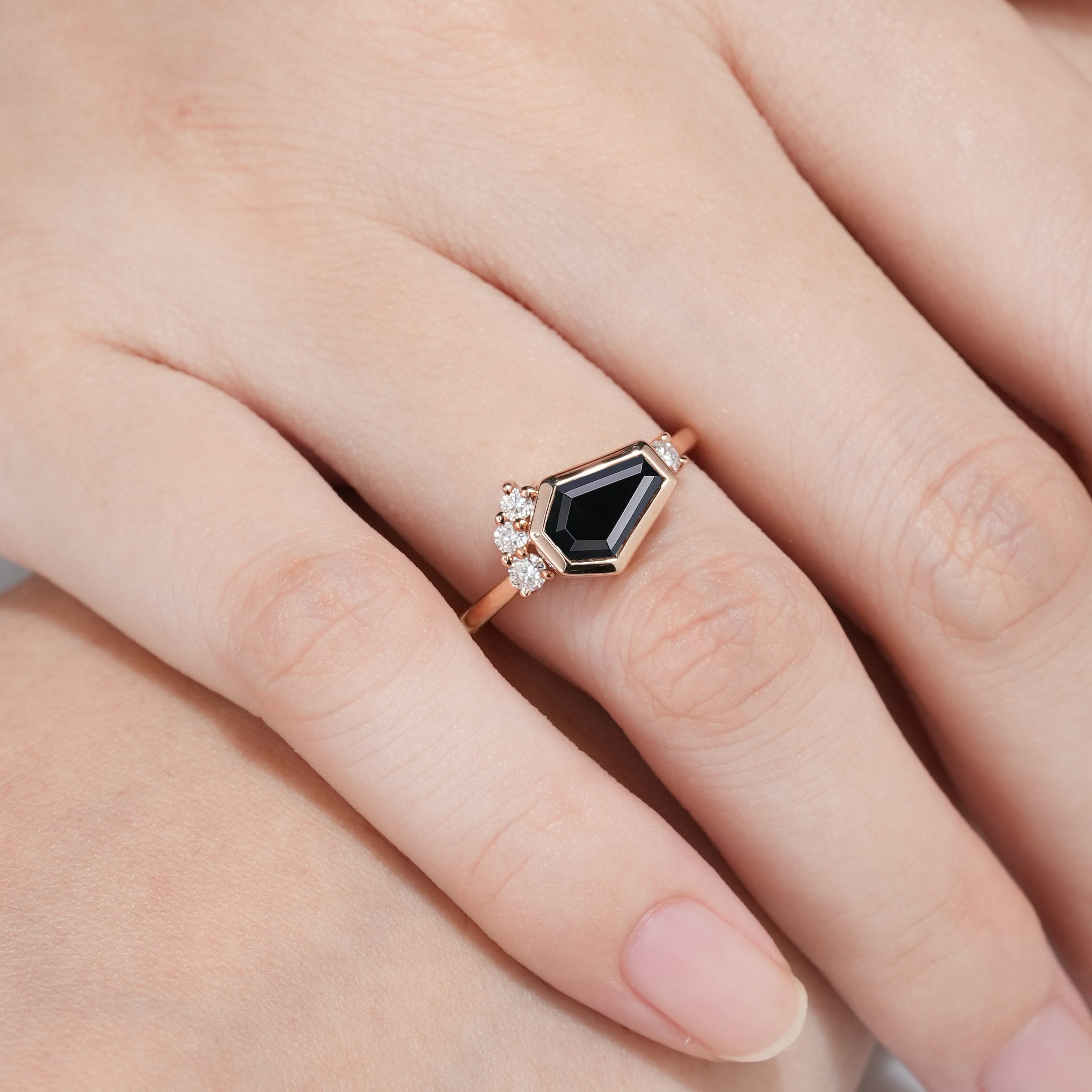 Black onyx coffin cut engagement ring on a finger