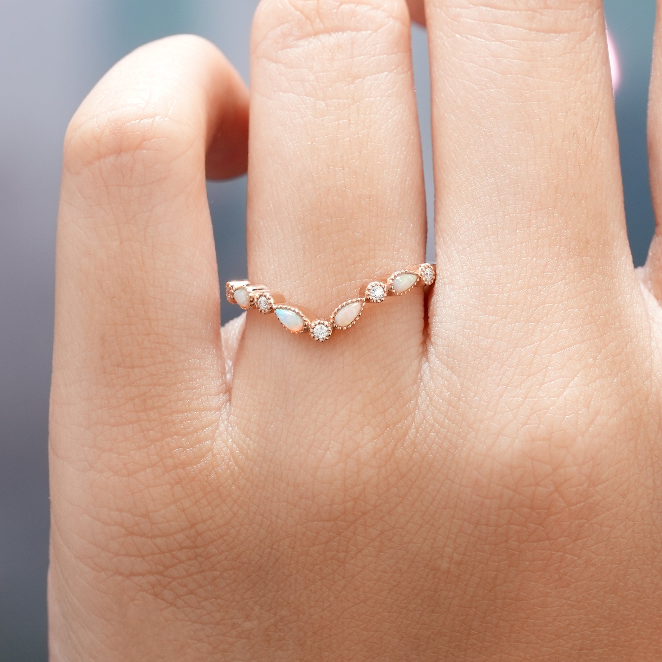 Hand wearing a Rose Gold Chevron Wedding Band with Opal and Moissanite