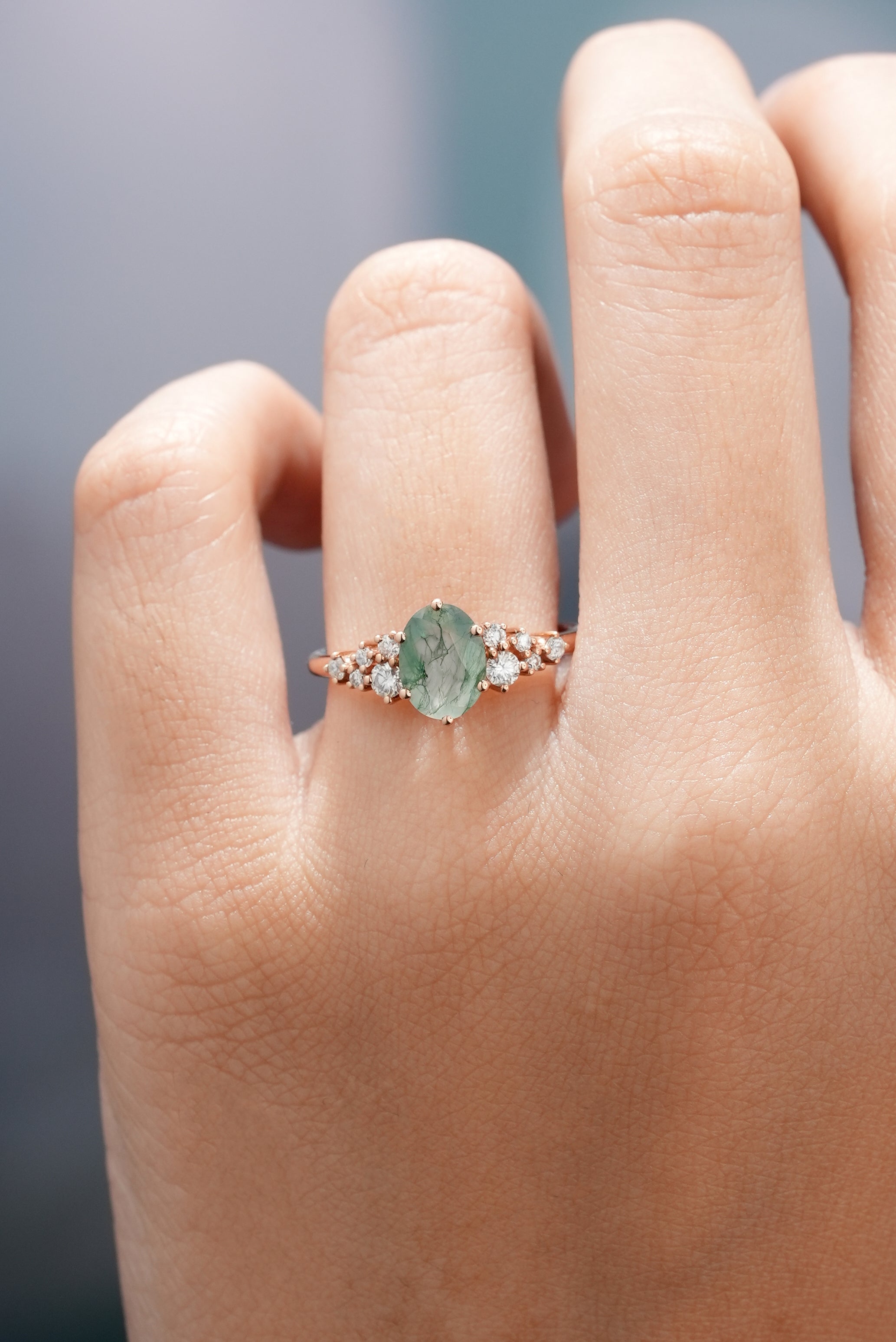 Close-up of moss agate ring on a finger