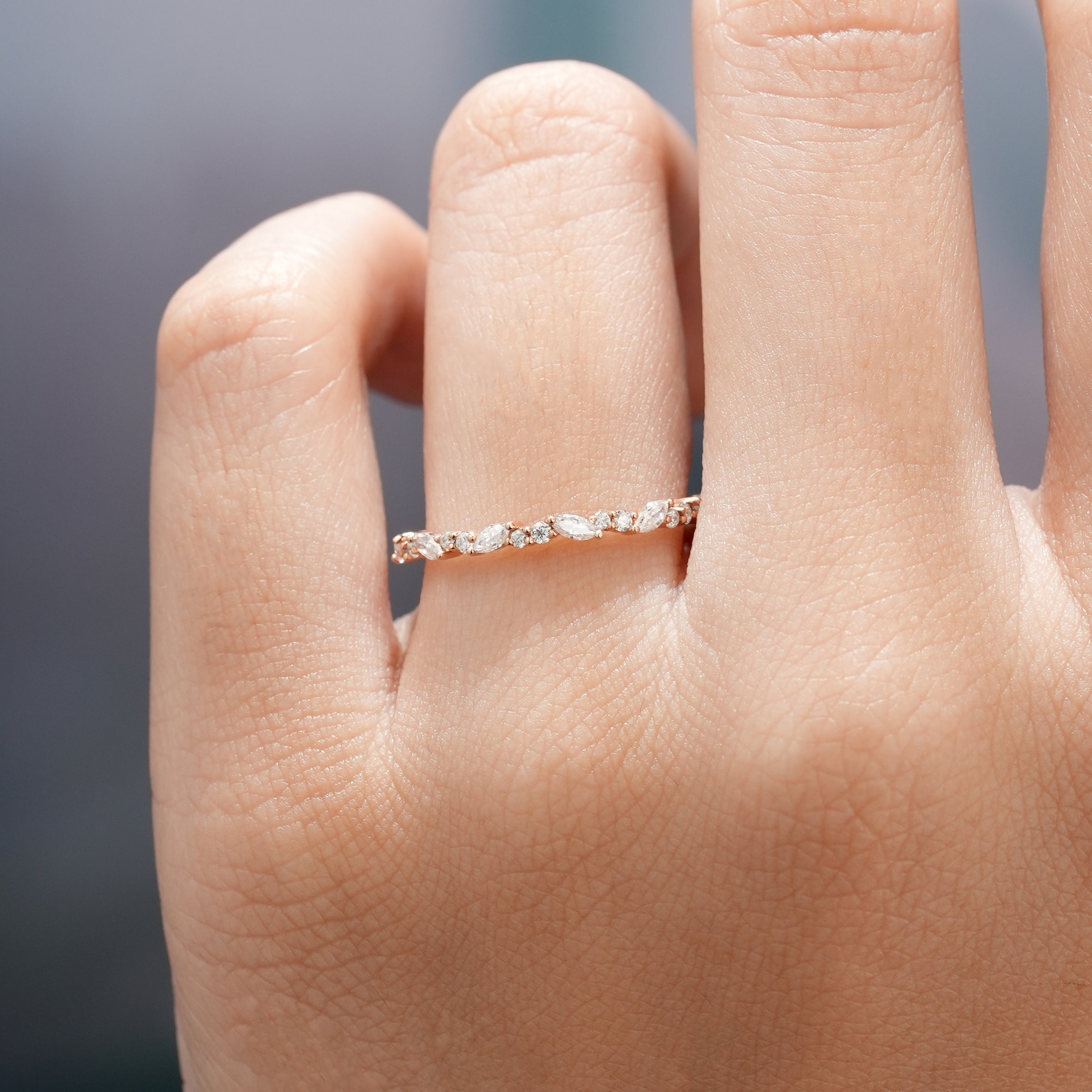 Hand wearing marquise cut moissanite stacking band