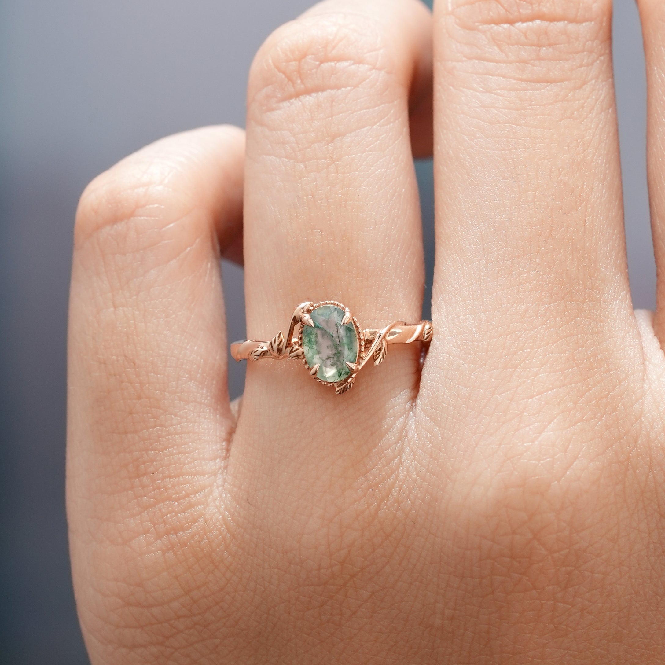 Rose gold Leafy Moss Agate ring on a finger