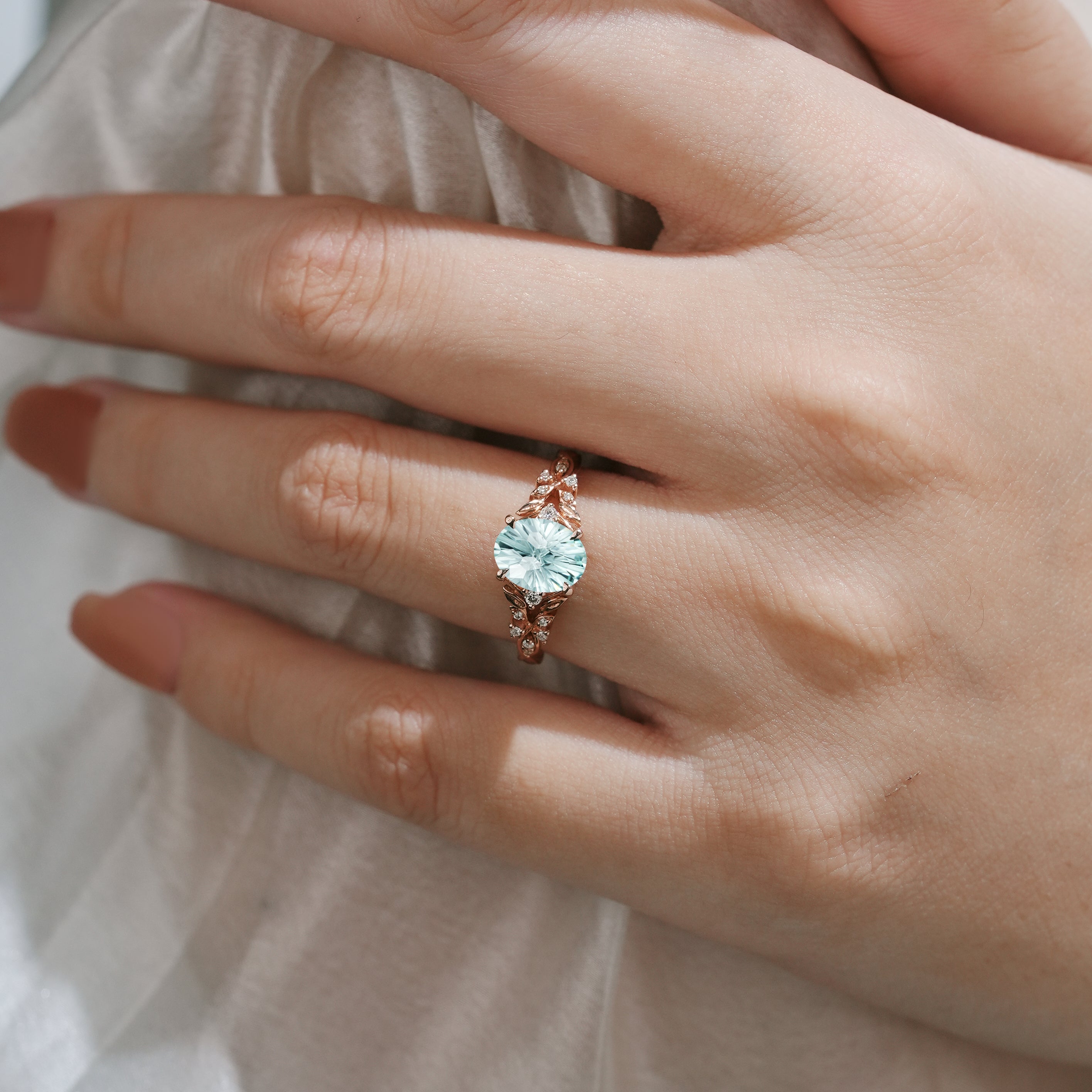 Rose gold aquamarine leaf engagement ring on a hand