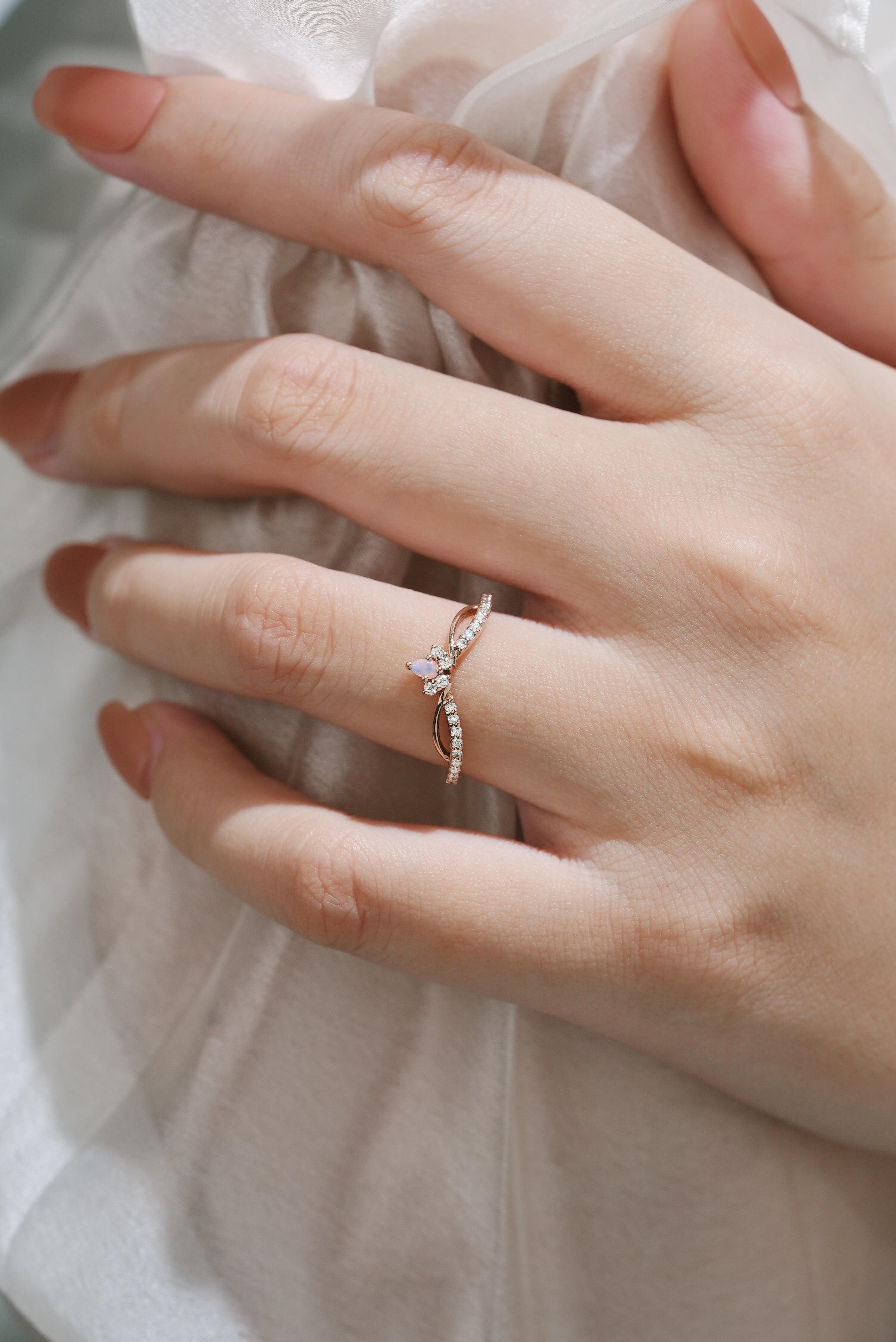 Rose gold engagement ring with opal center stone and moissanite accents, bridal ring set