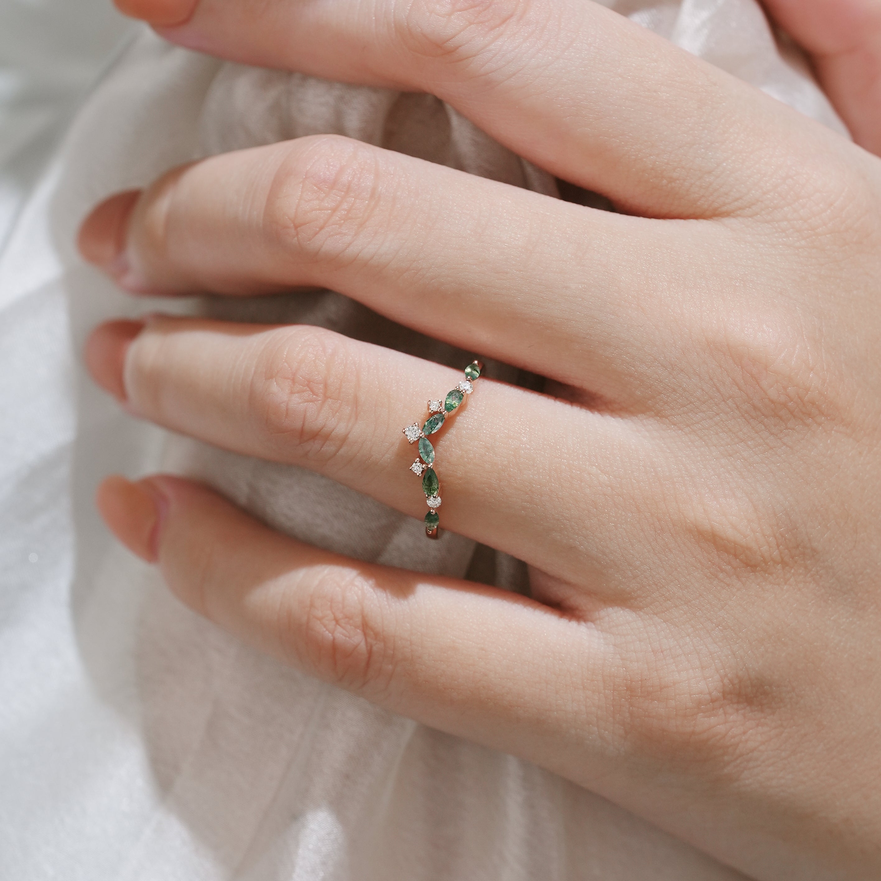 Hand wearing curved moss agate wedding band